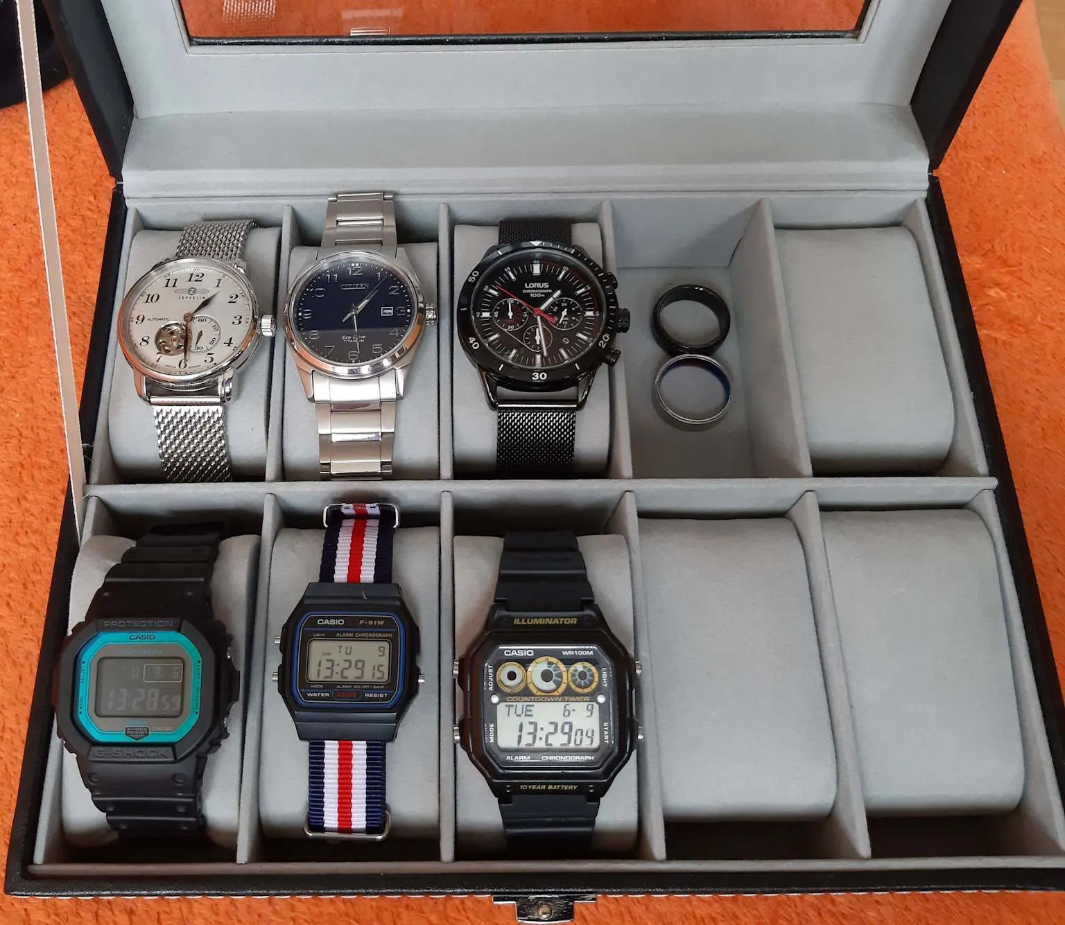 An affordable watch collection featuring analog and digital Casio watches neatly organized in a display box