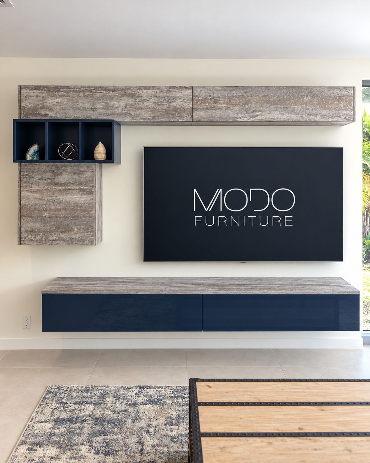 Floating stone-look wall cabinets with a navy open niche around a wall-mounted TV and a navy floating console