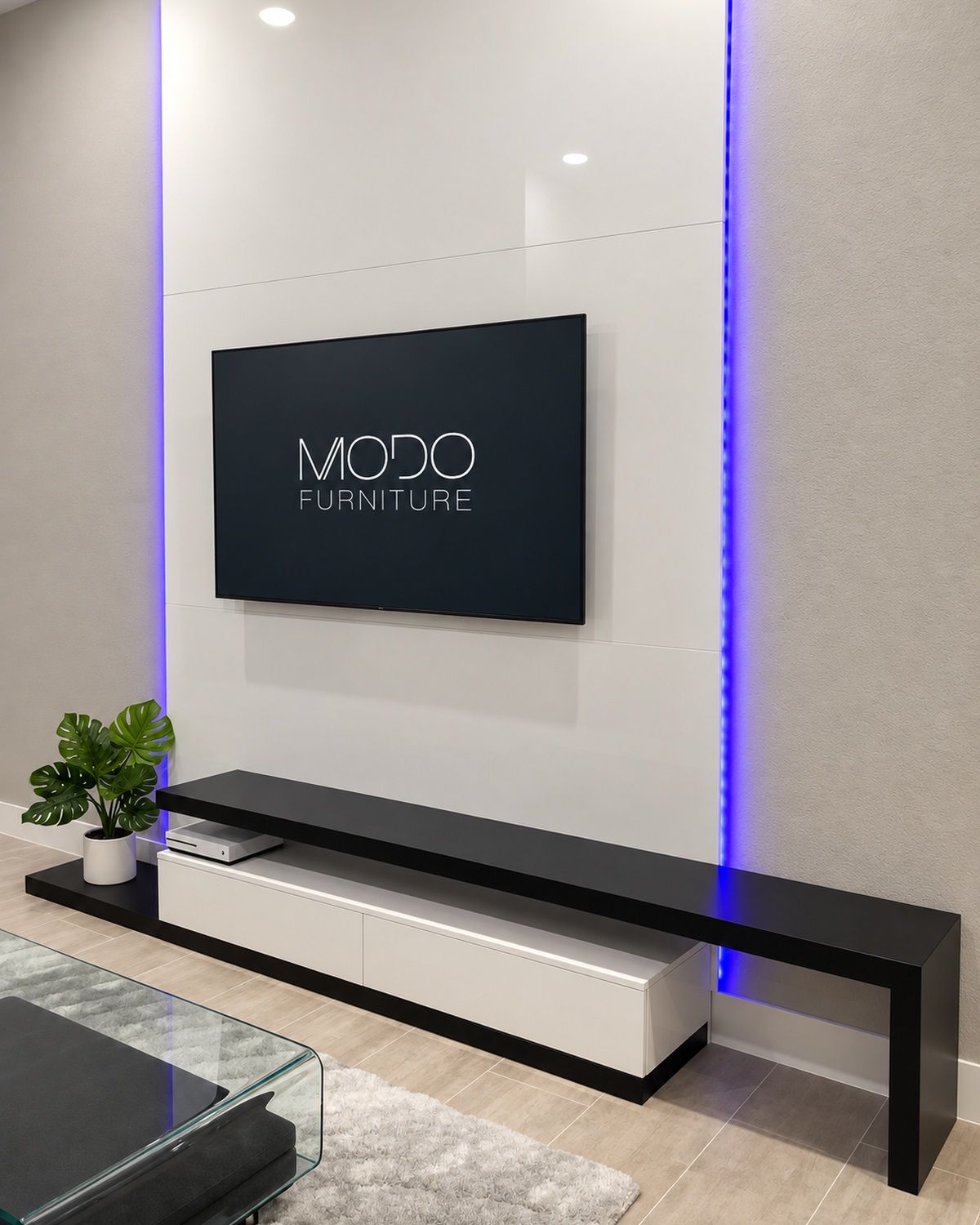 White panel TV wall with blue LED edge lighting above a long low black and white floating console