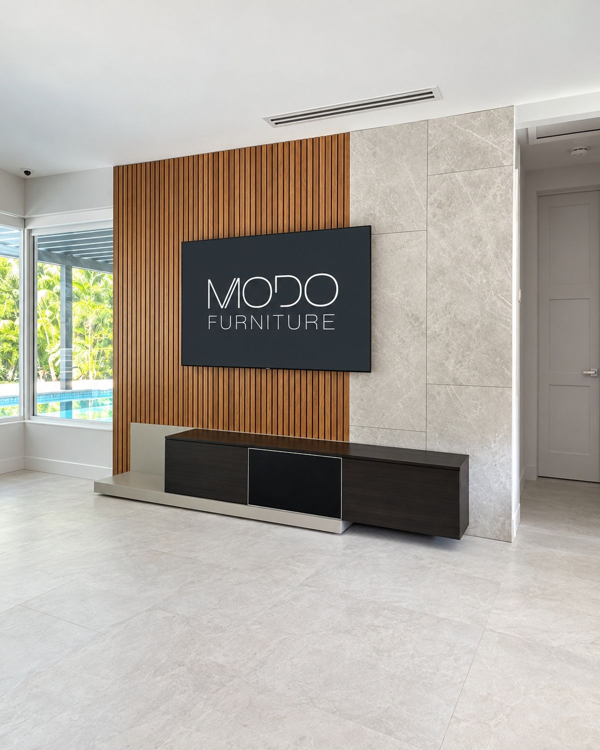 Wall-mounted TV between walnut slat paneling and gray stone tile, above a dark floating media console