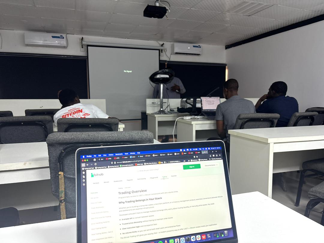 Kayandra Samuel on Stage and a Macbook on table with the Bitnob API Documentation opened