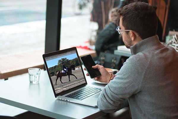 A coach coaching a horse rider during a remote live lesson