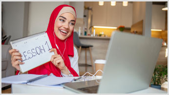 A tutor holding a cue card for a tutor she is teaching online.