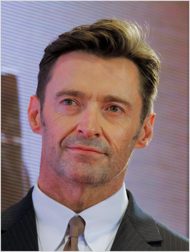 Hugh Jackman - former PE teacher and actor Hugh Jackman in a suit on a stage; he worked as a PE teacher in England before his film career.