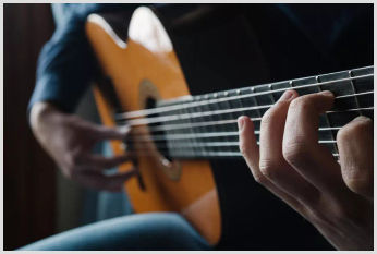 A close-up of a musician playing the guitar.