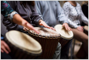 A close-up of a group playing the drums.