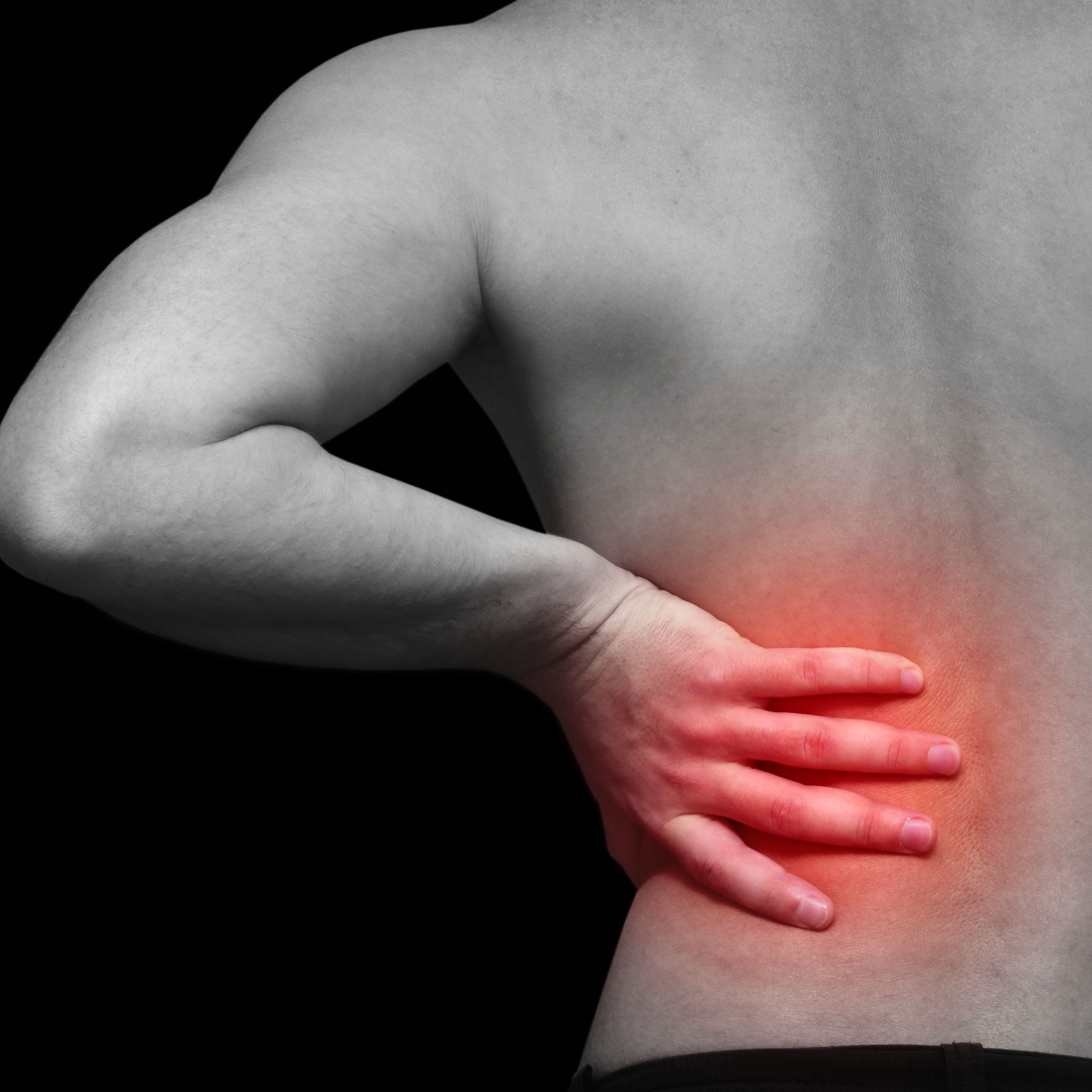 person holds back that is glowing from pain