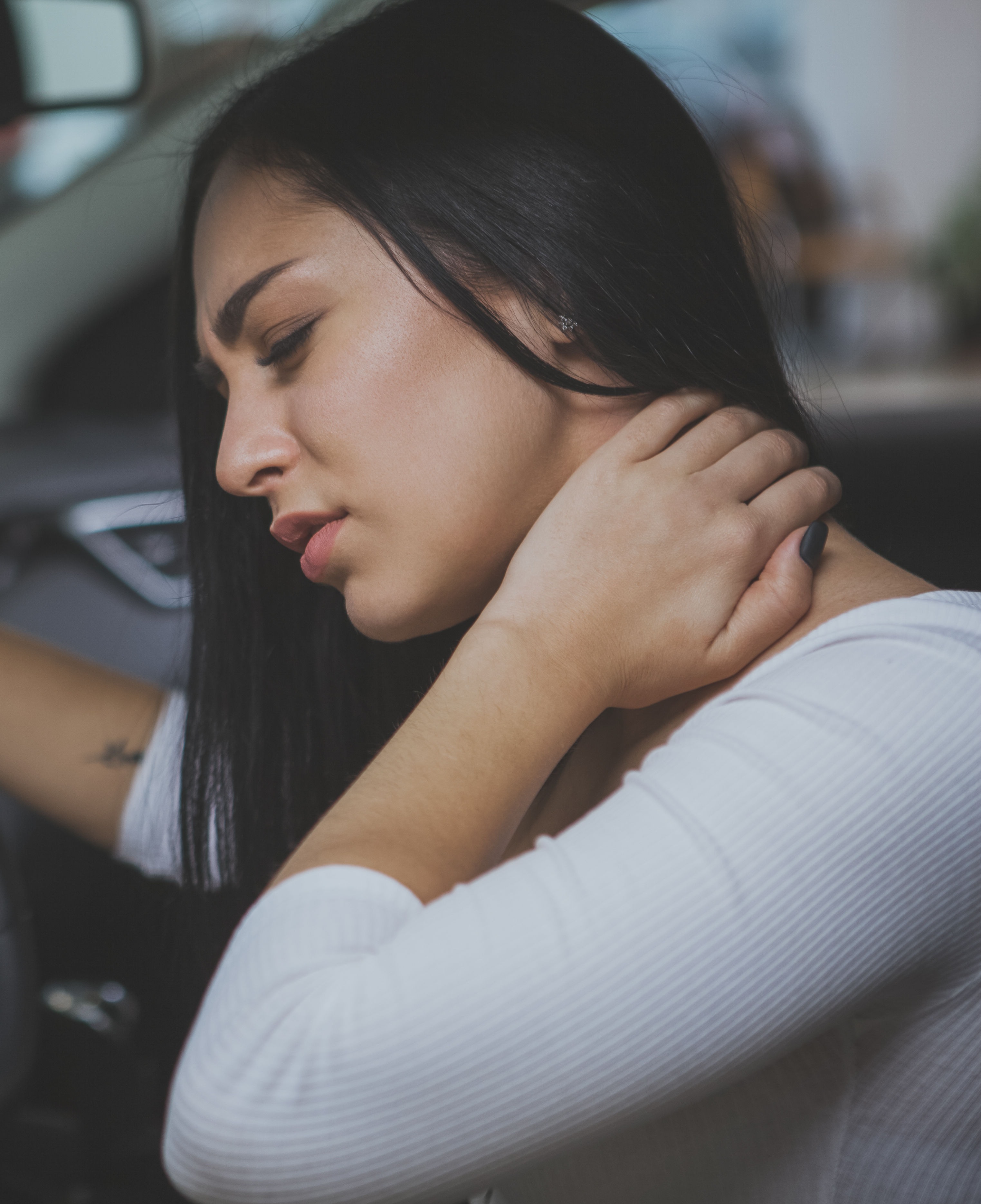 Female driver rubbing her aching neck after long d