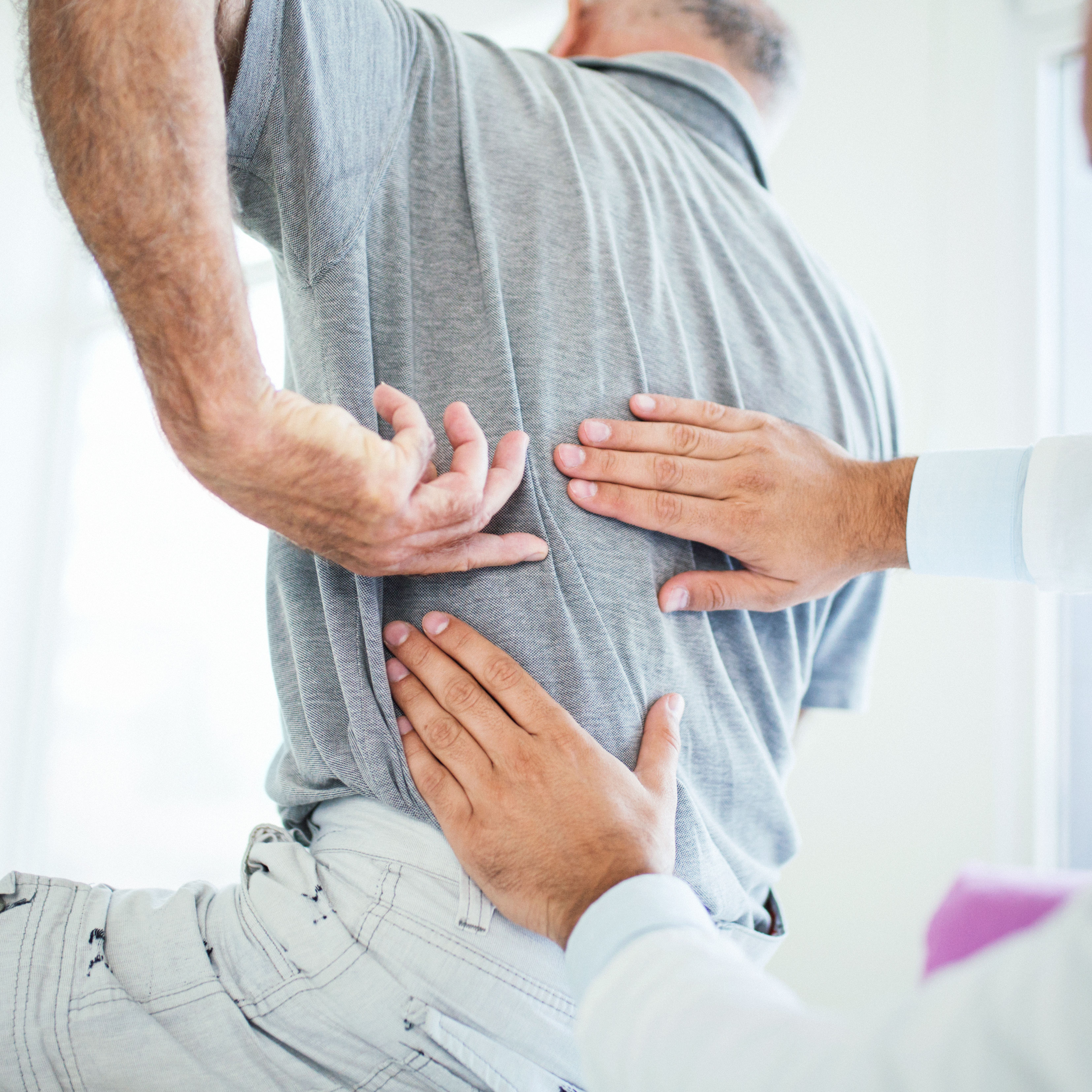 doctor evaluating patient's back pain