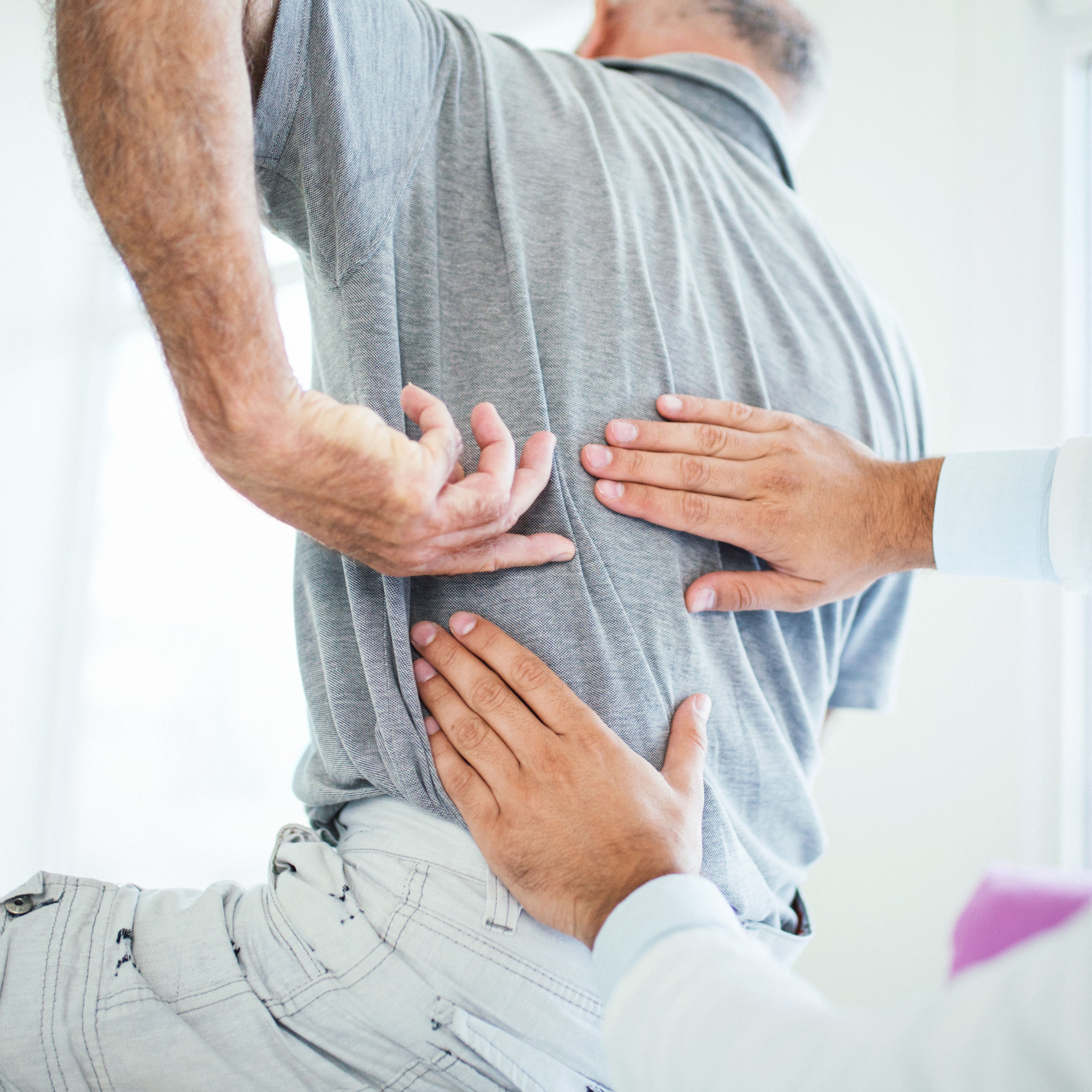 doctor evaluating patient's back pain