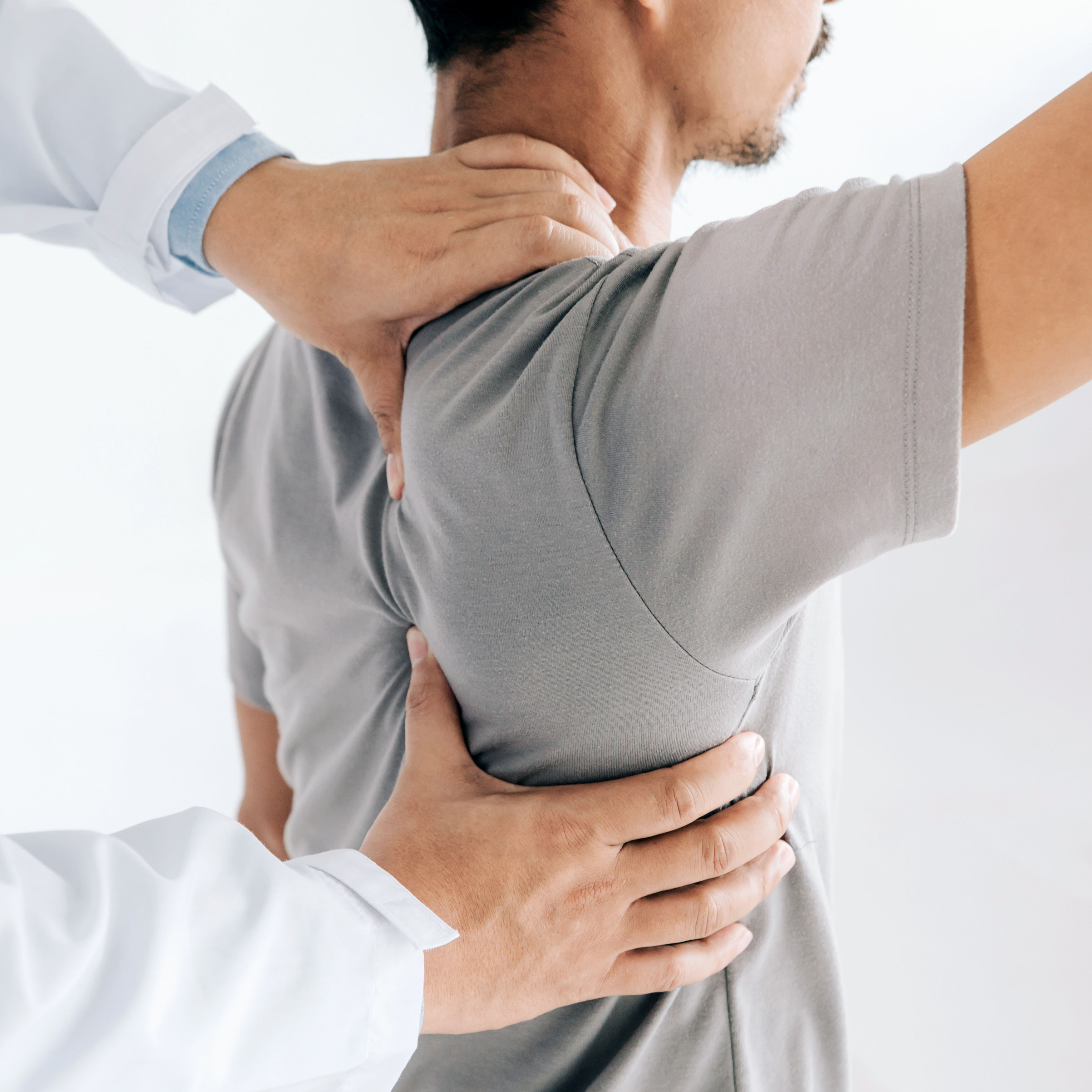 Physiotherapist doing healing treatment on mans ba