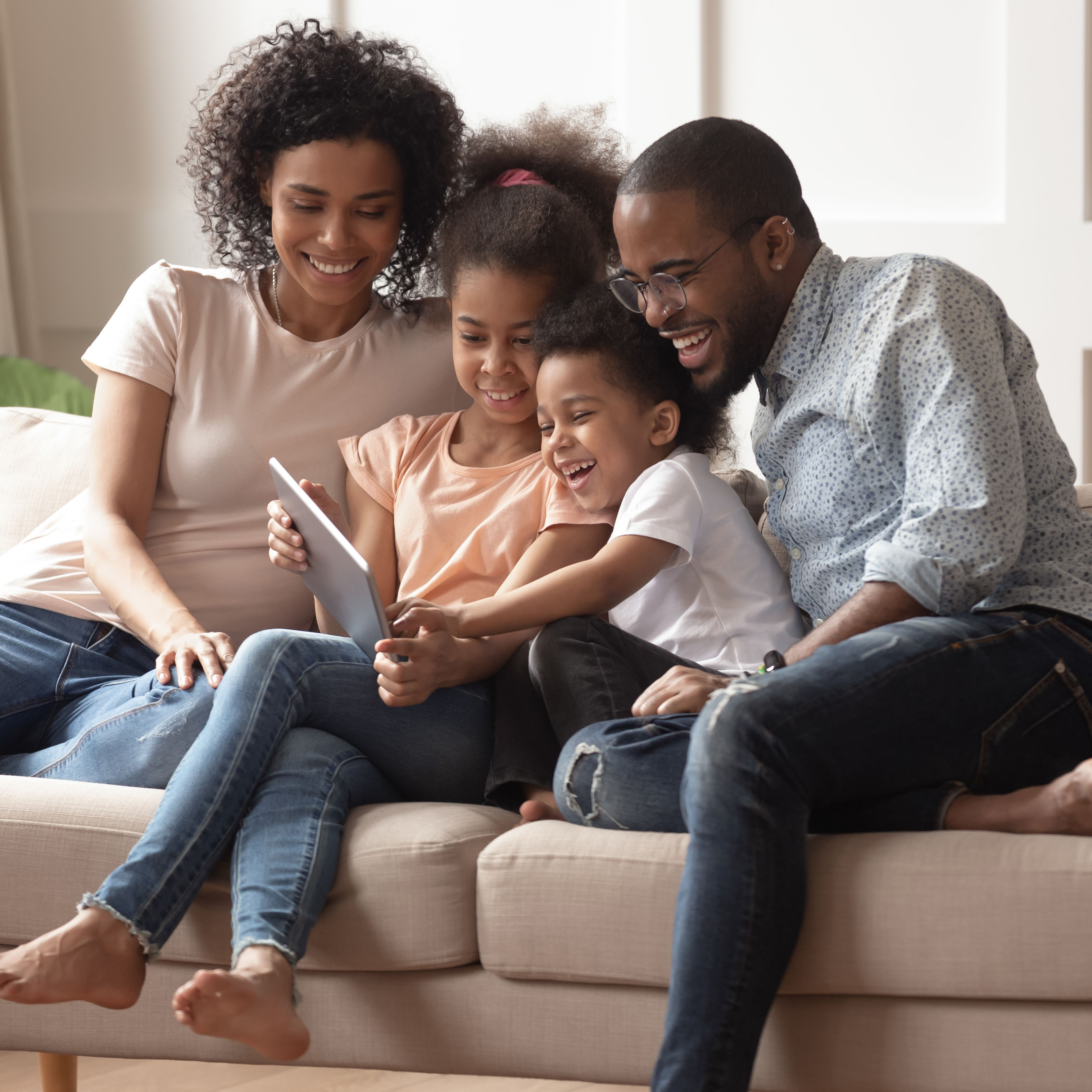 Happy black parents and children using digital tab