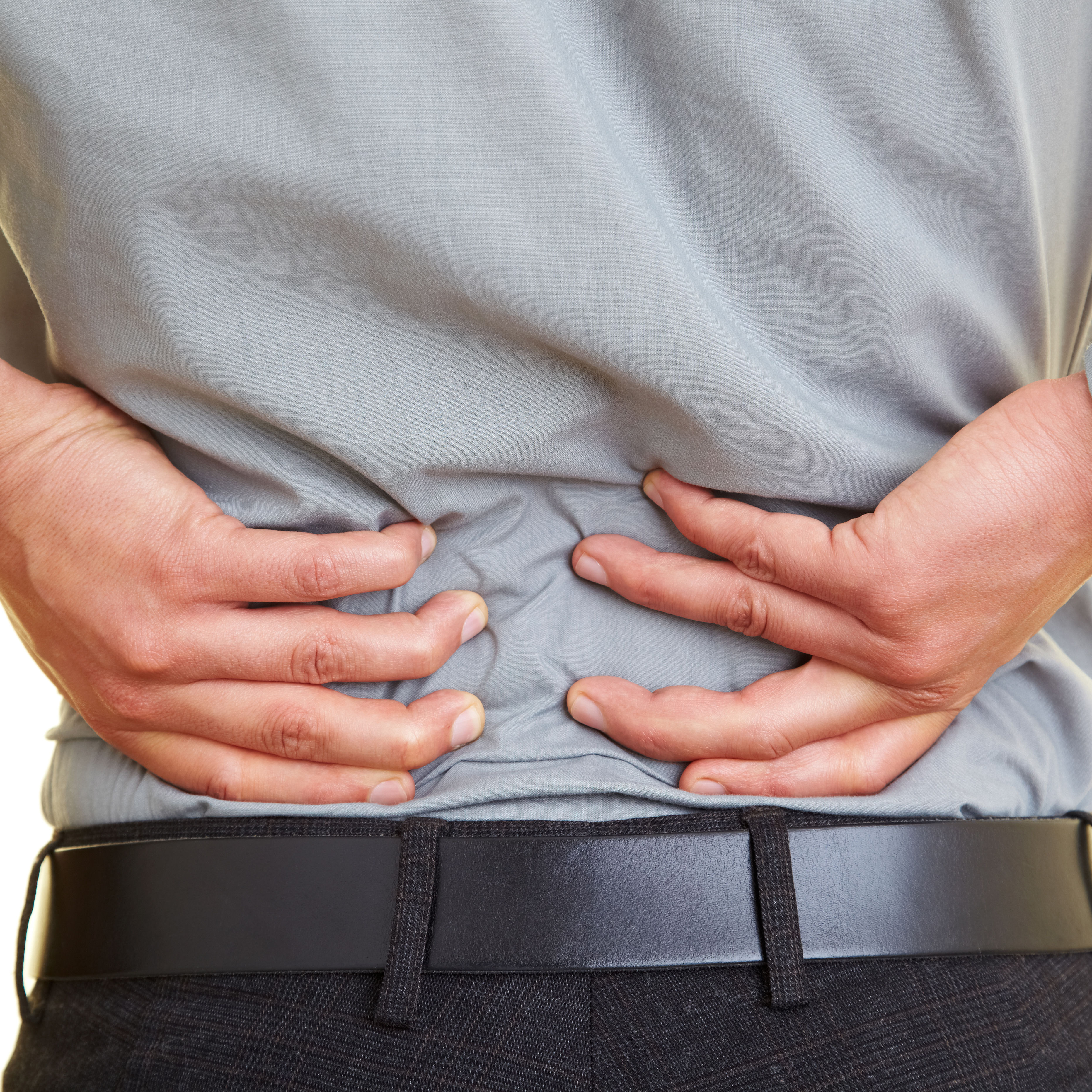 back of middle half of clothed white male with hands on low back pain