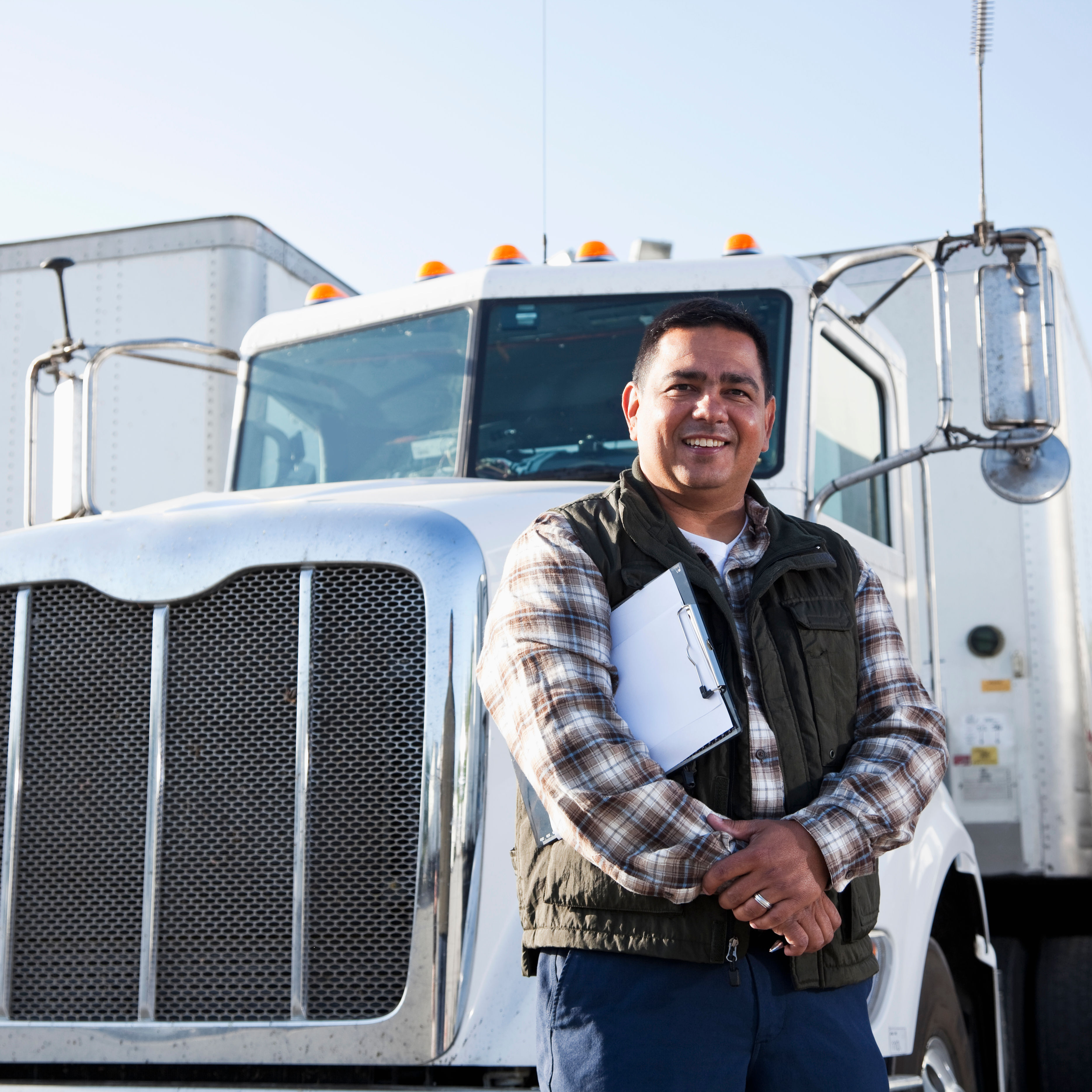 Hispanic truck driver with clipboard