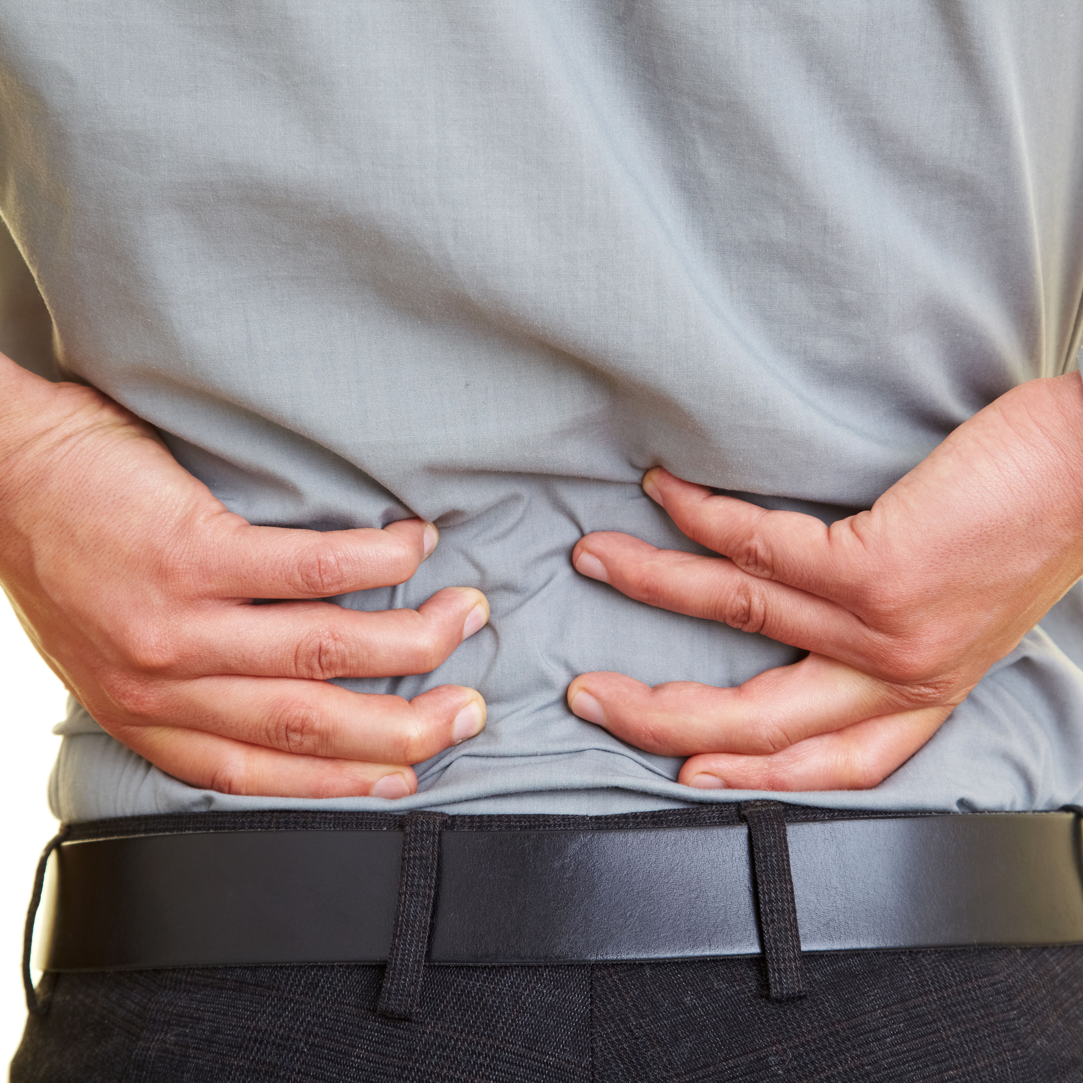 back of middle half of clothed white male with hands on low back pain