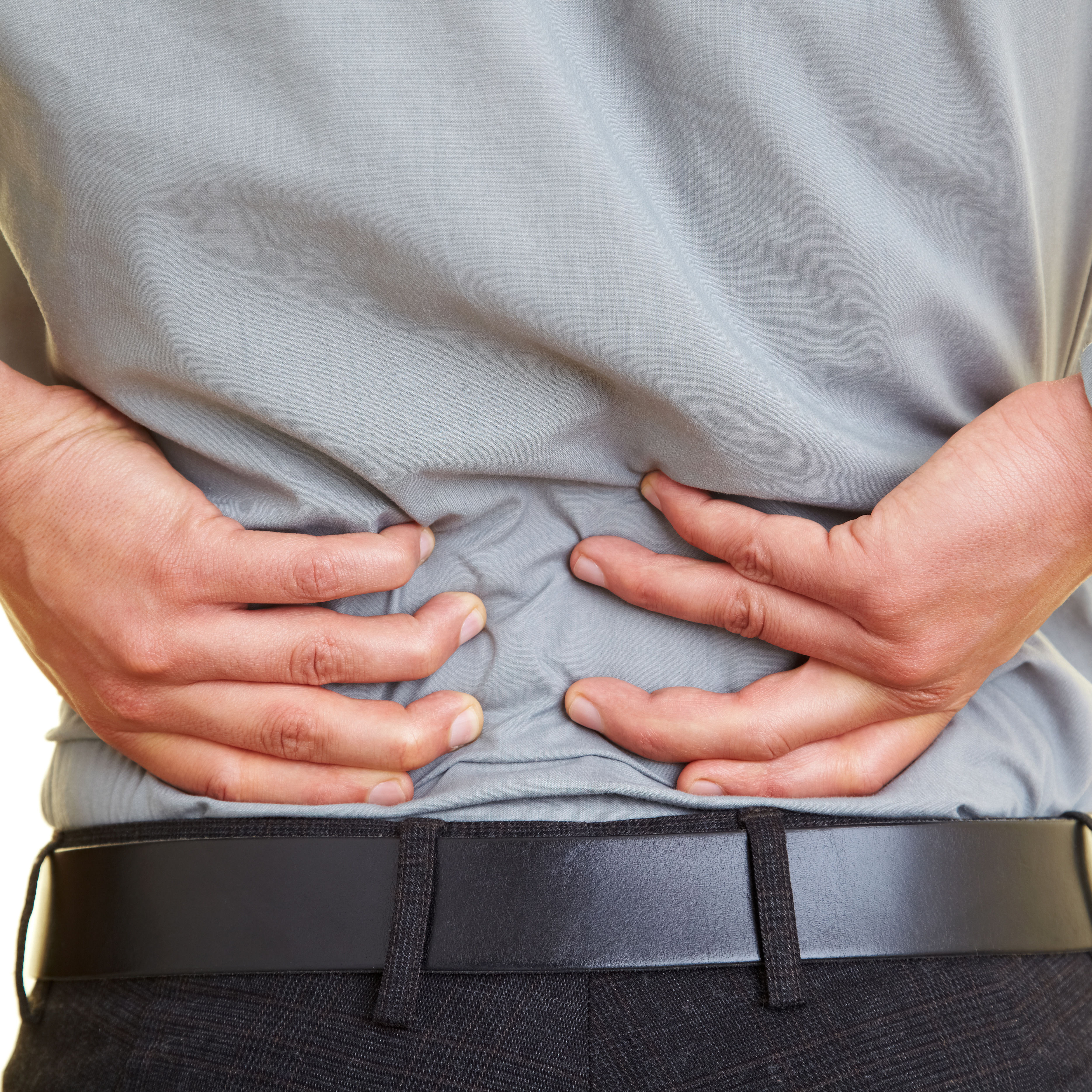 back of middle half of clothed white male with hands on low back pain