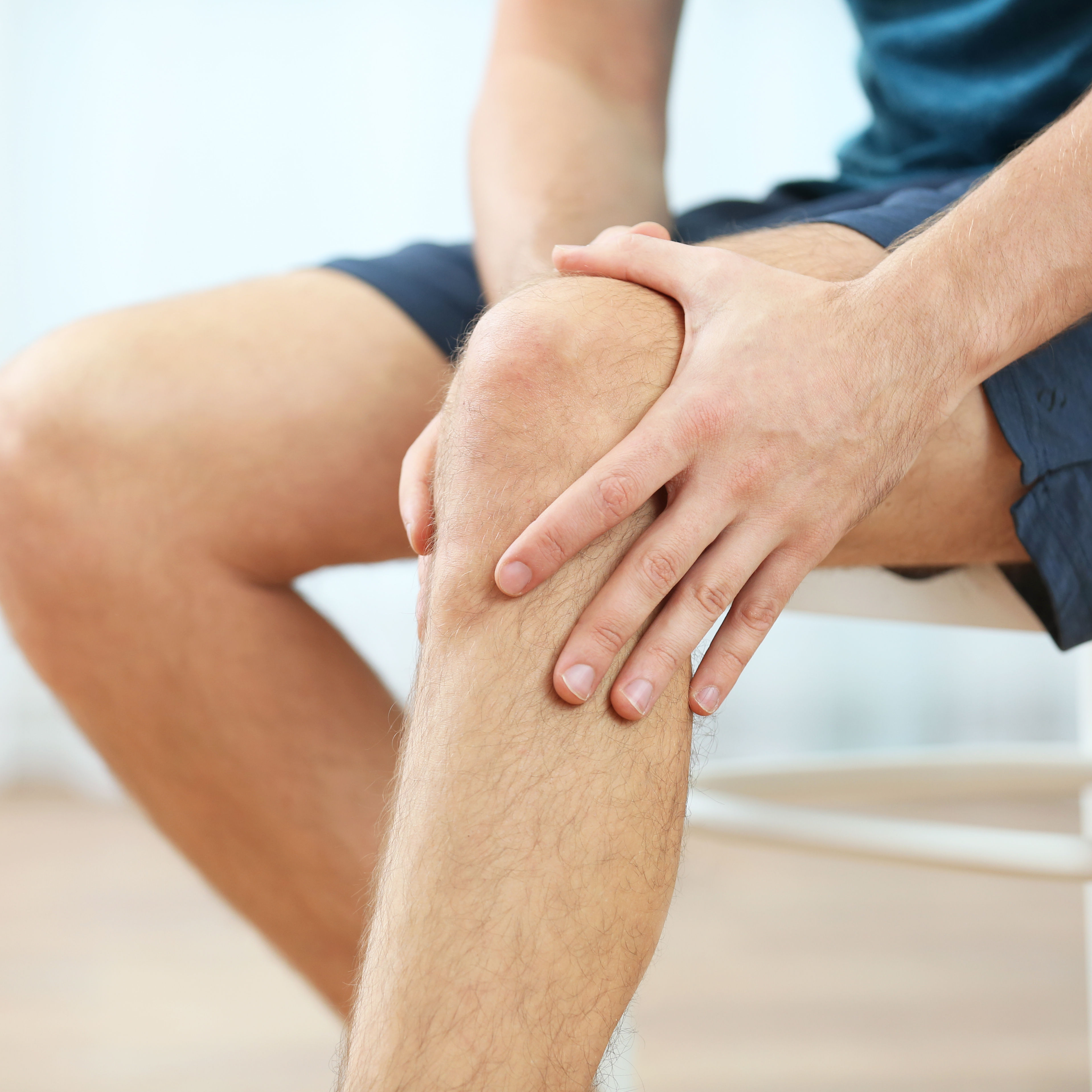  Young man holding knee