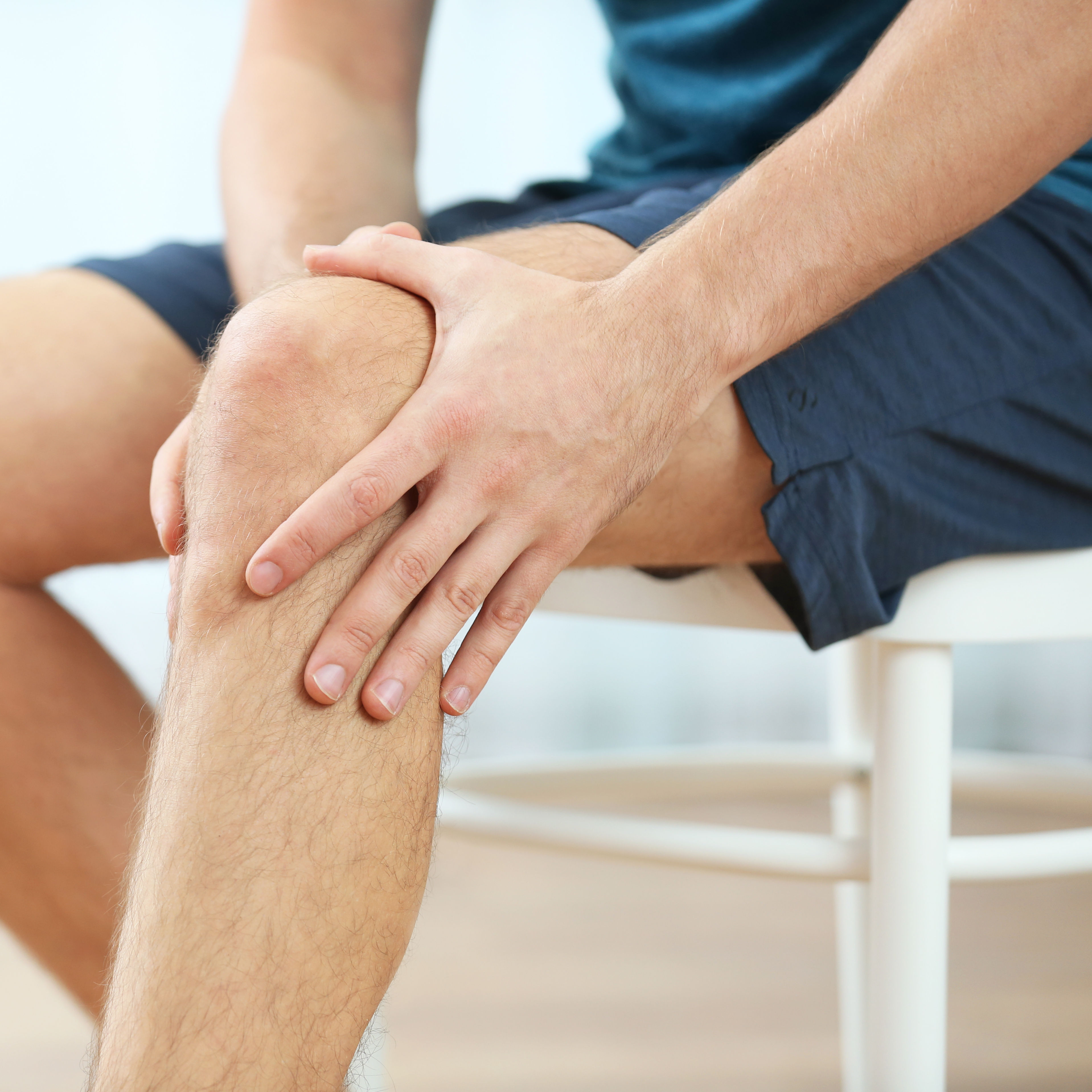  Young man holding knee