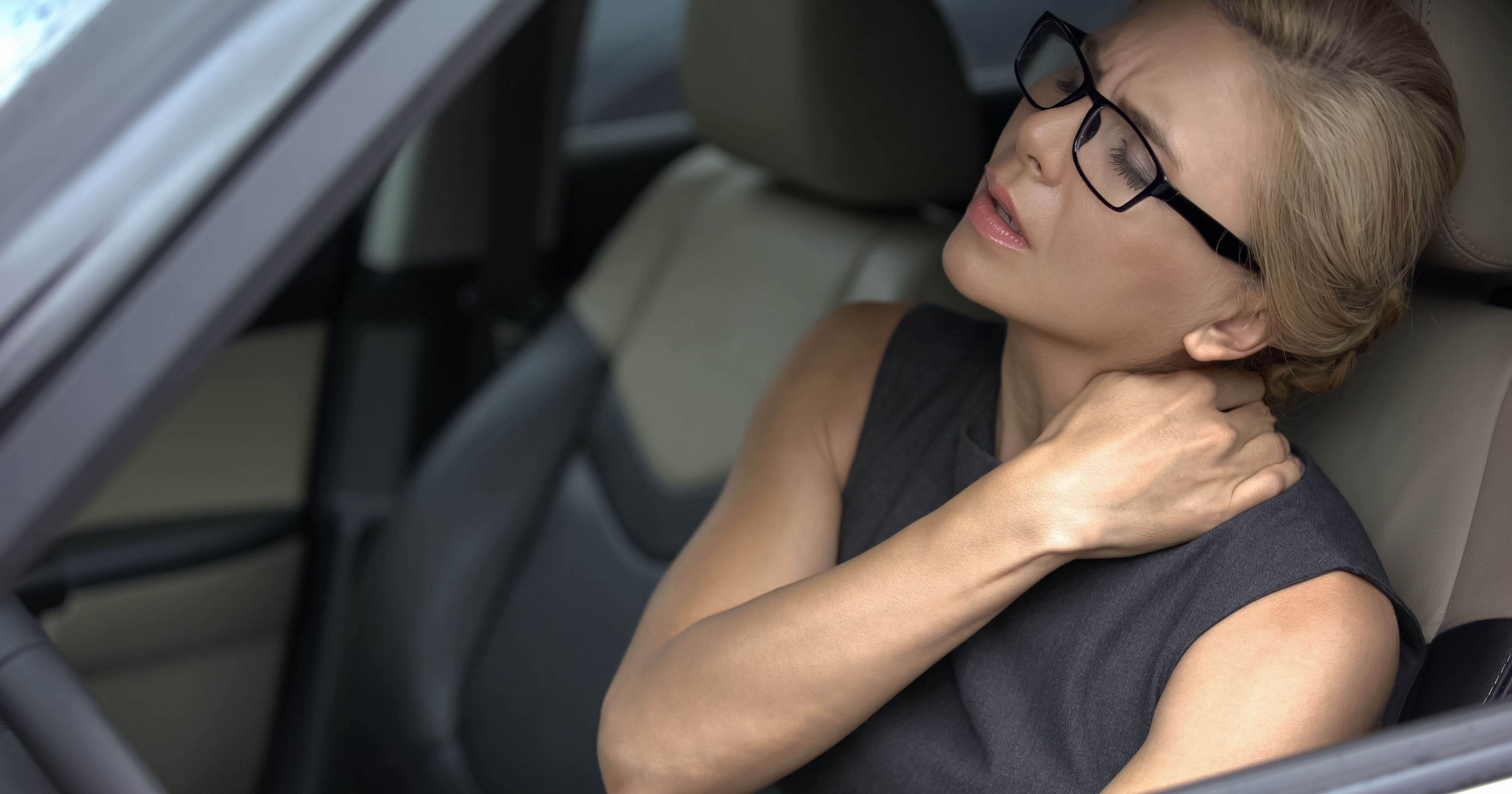 female driver suffering from neck and shoulder pain