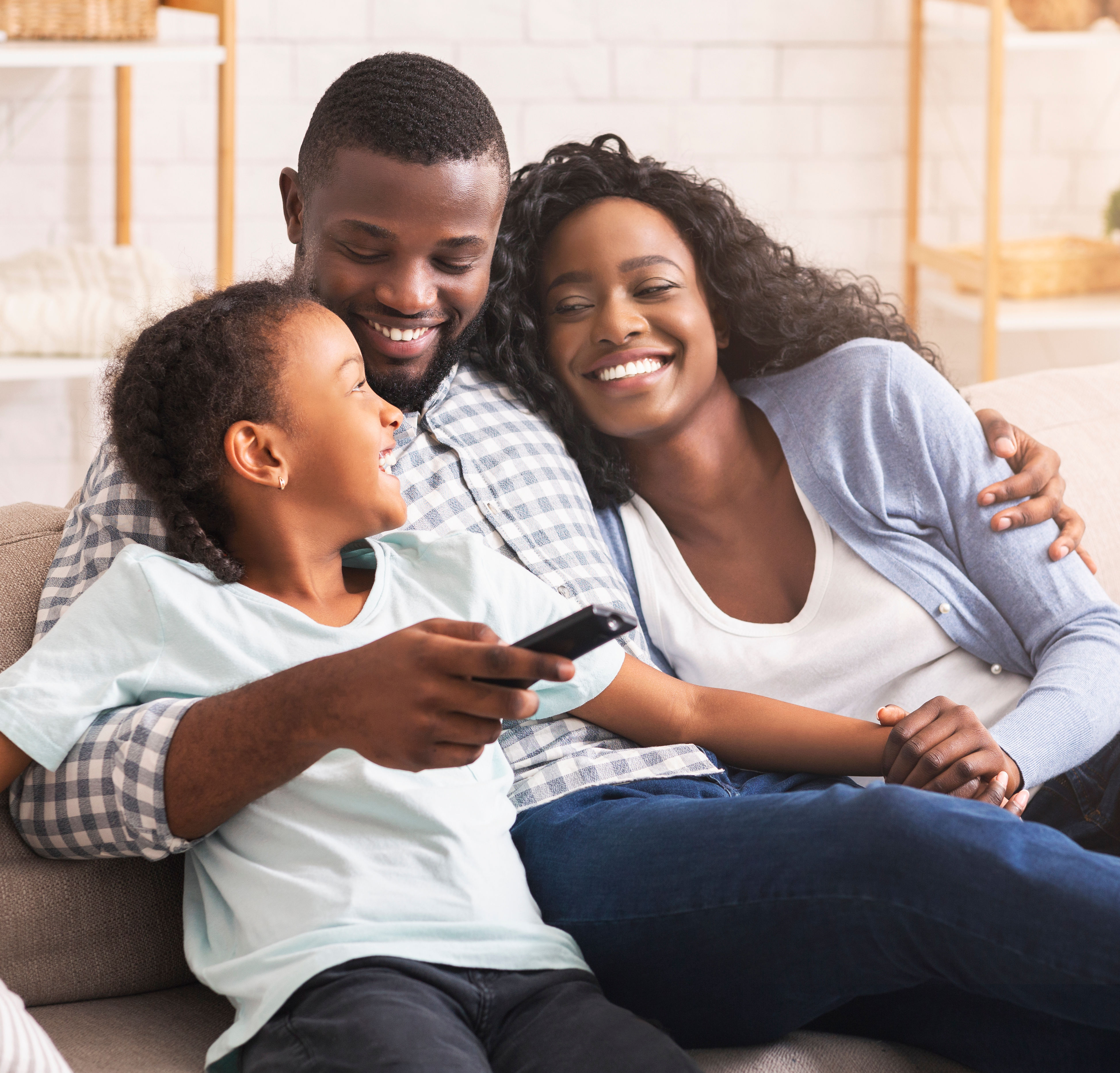 Happy african american family relaxing and watchin