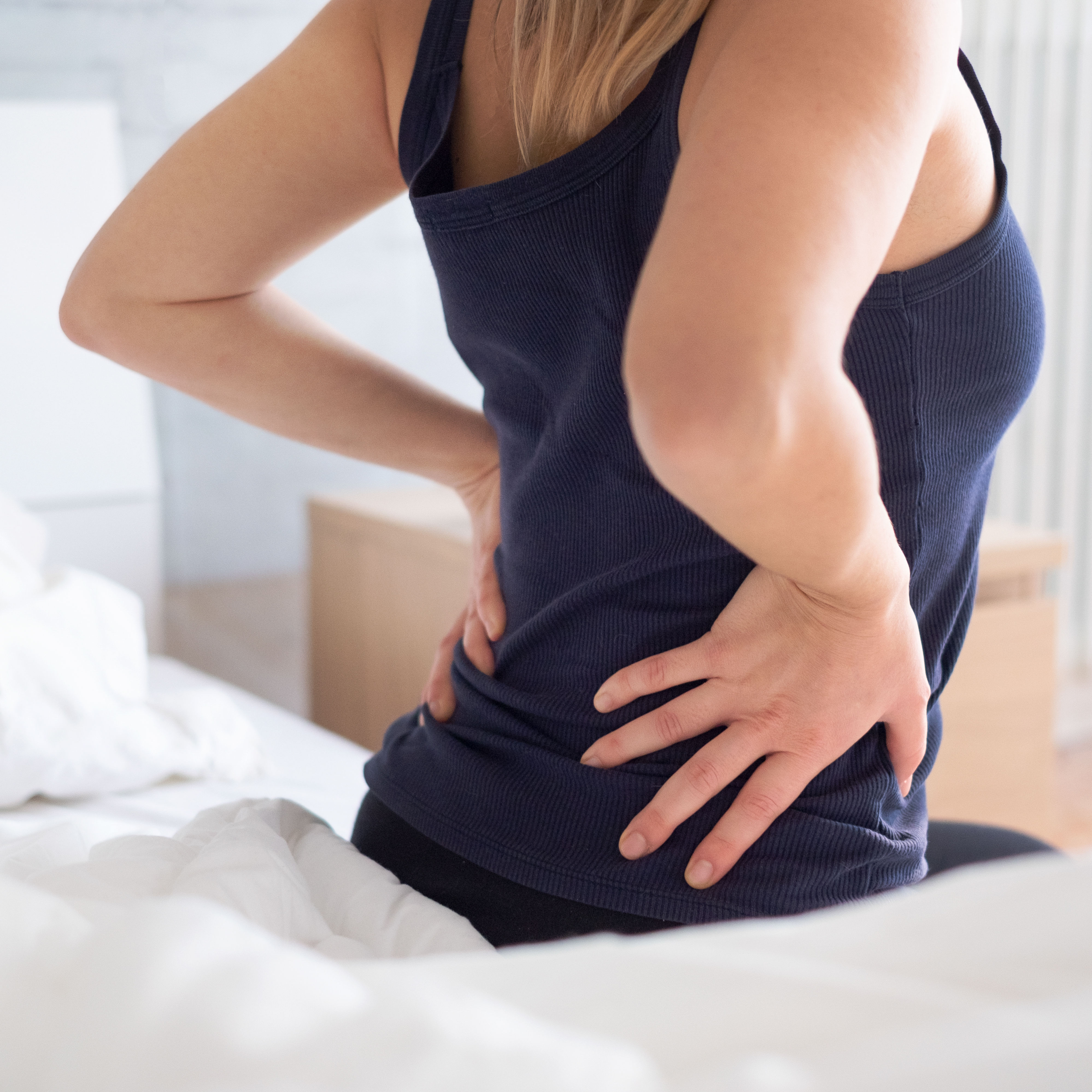 Painful woman awakening and feeling back pain