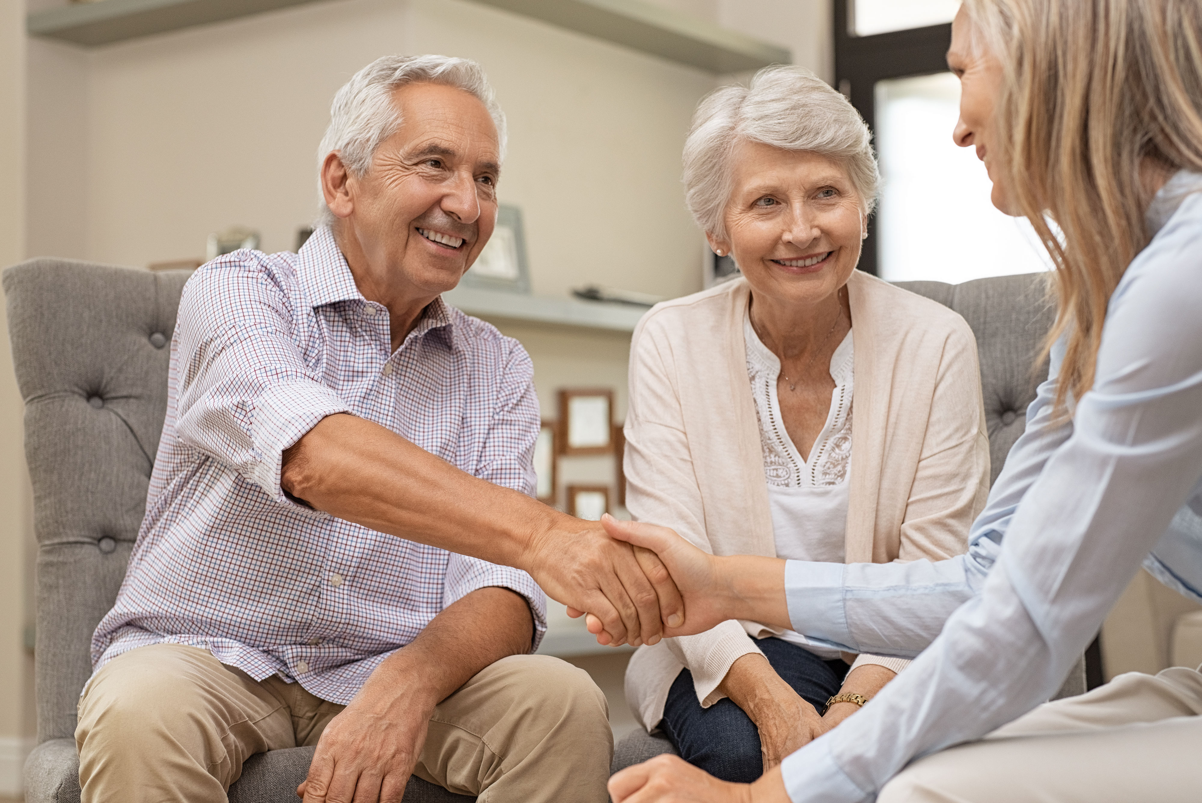 Senior couple shaking hands with financial advisor