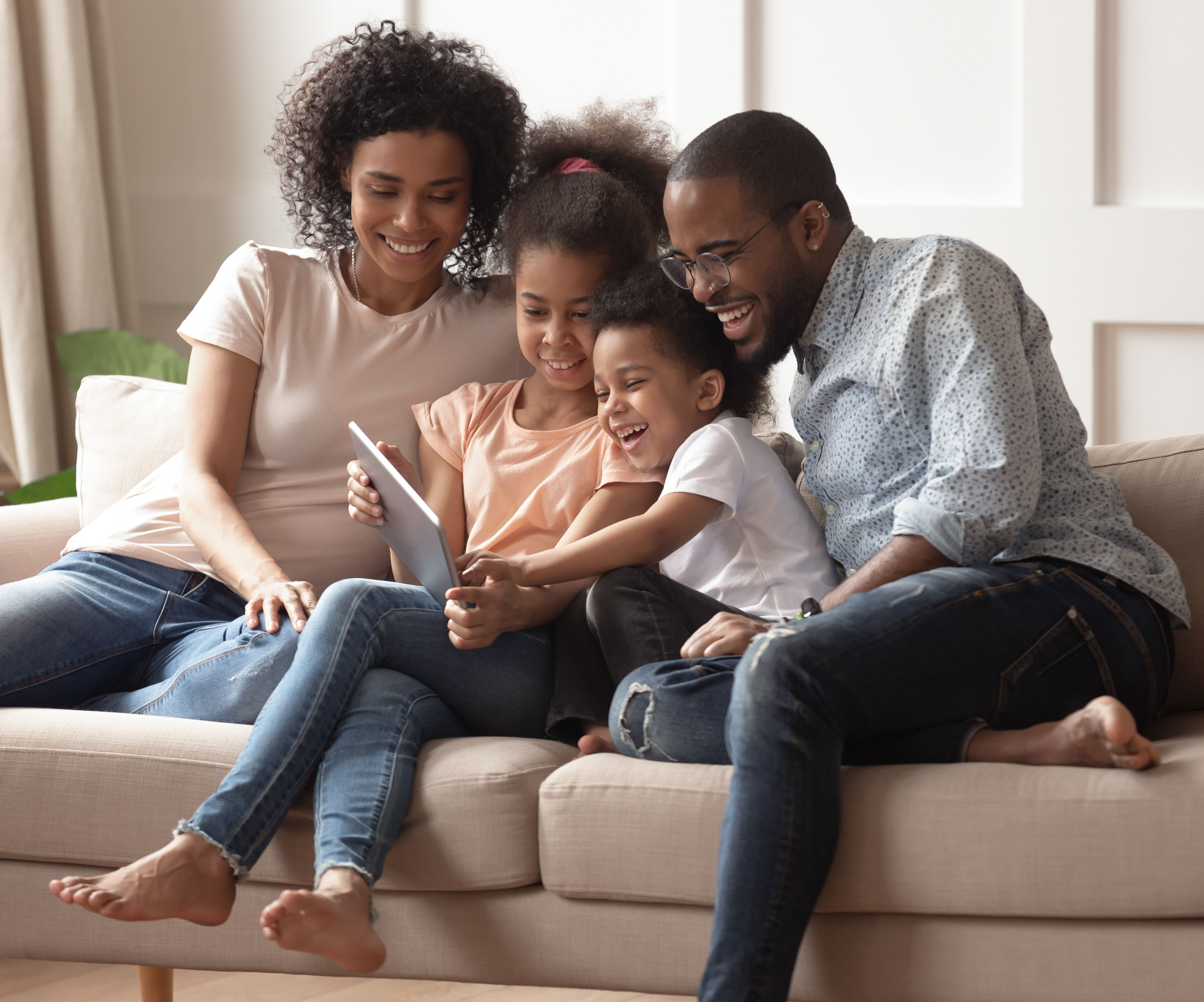 Happy black parents and children using digital tab