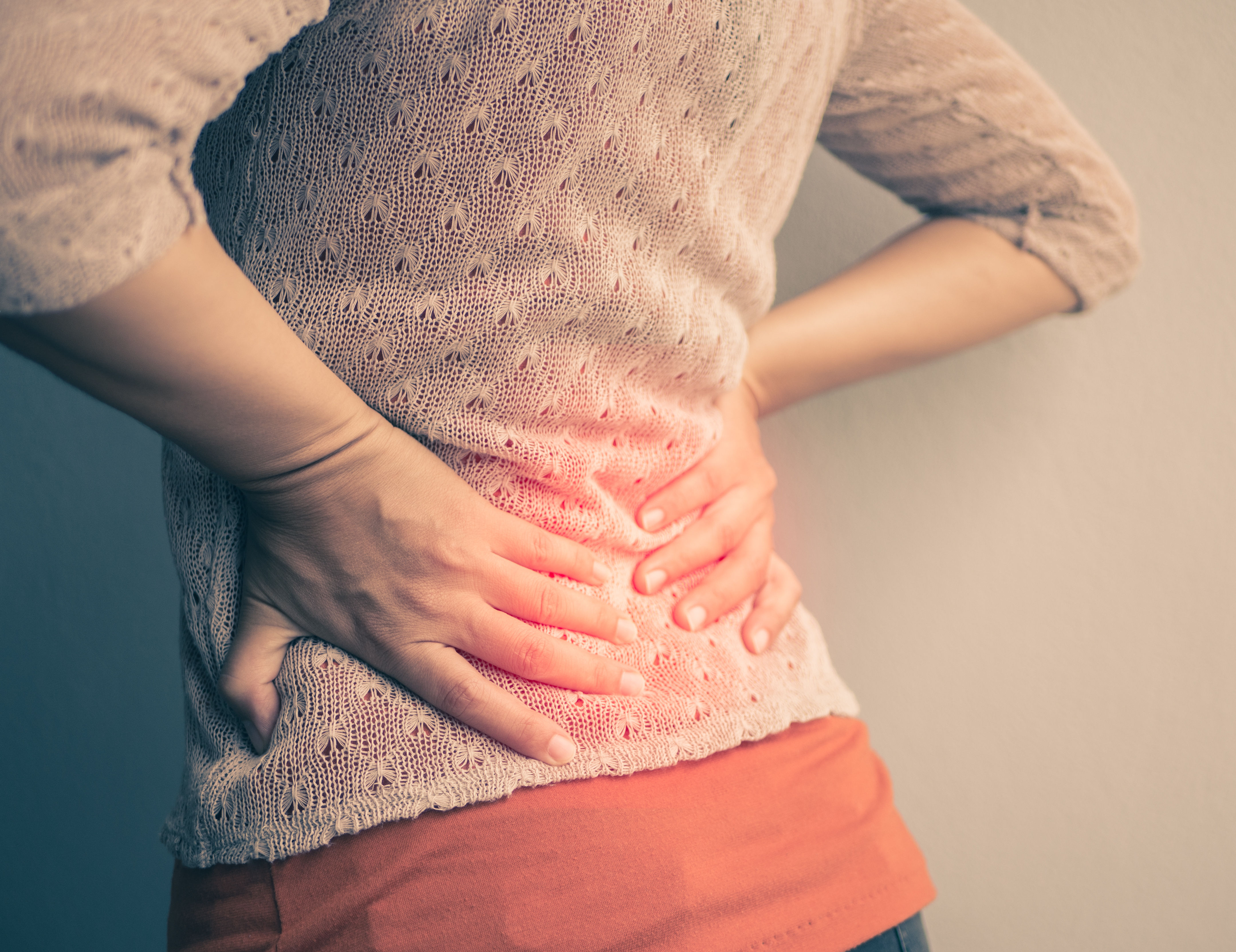 Closeup woman with hands holding her waist back in