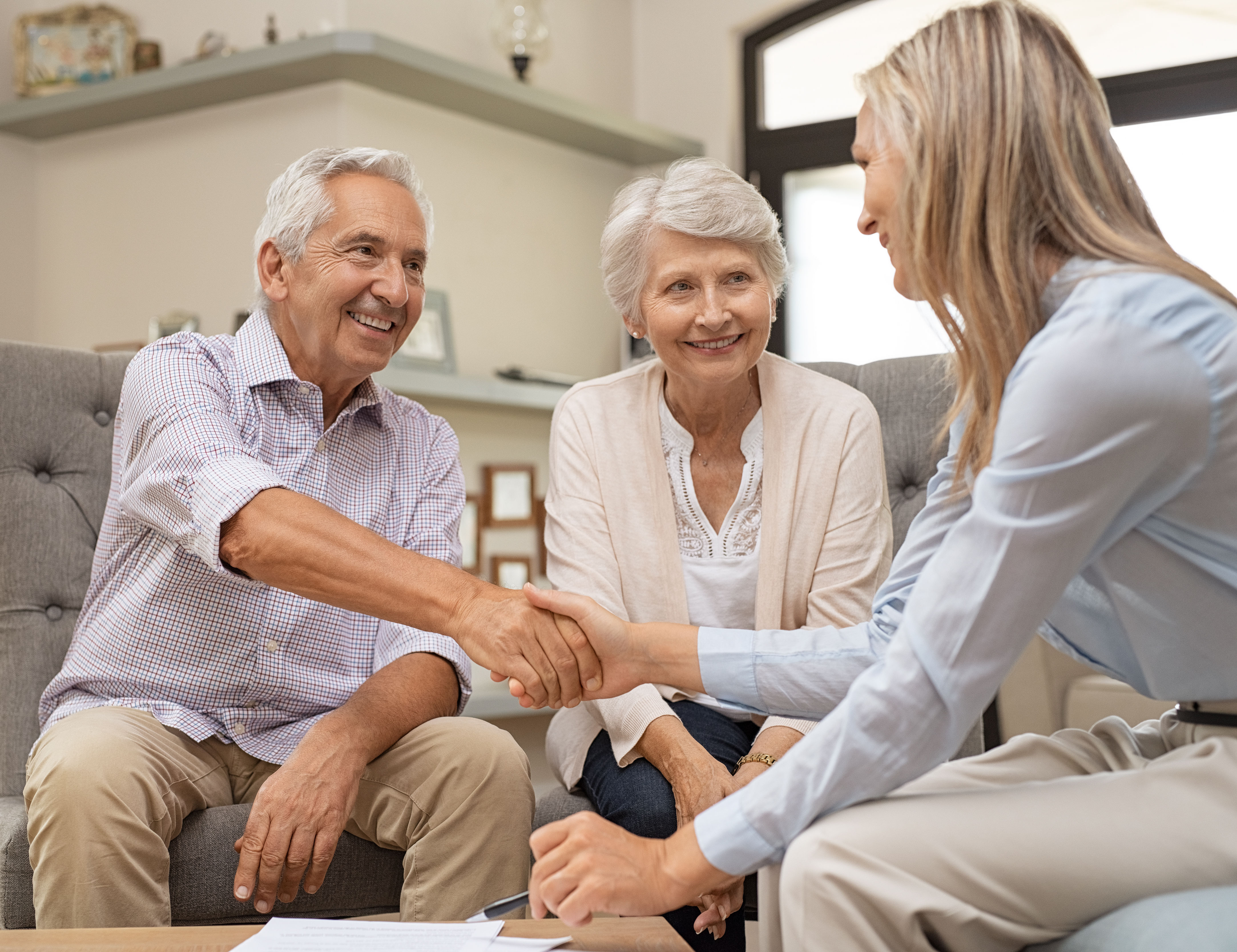 Senior couple shaking hands with financial advisor
