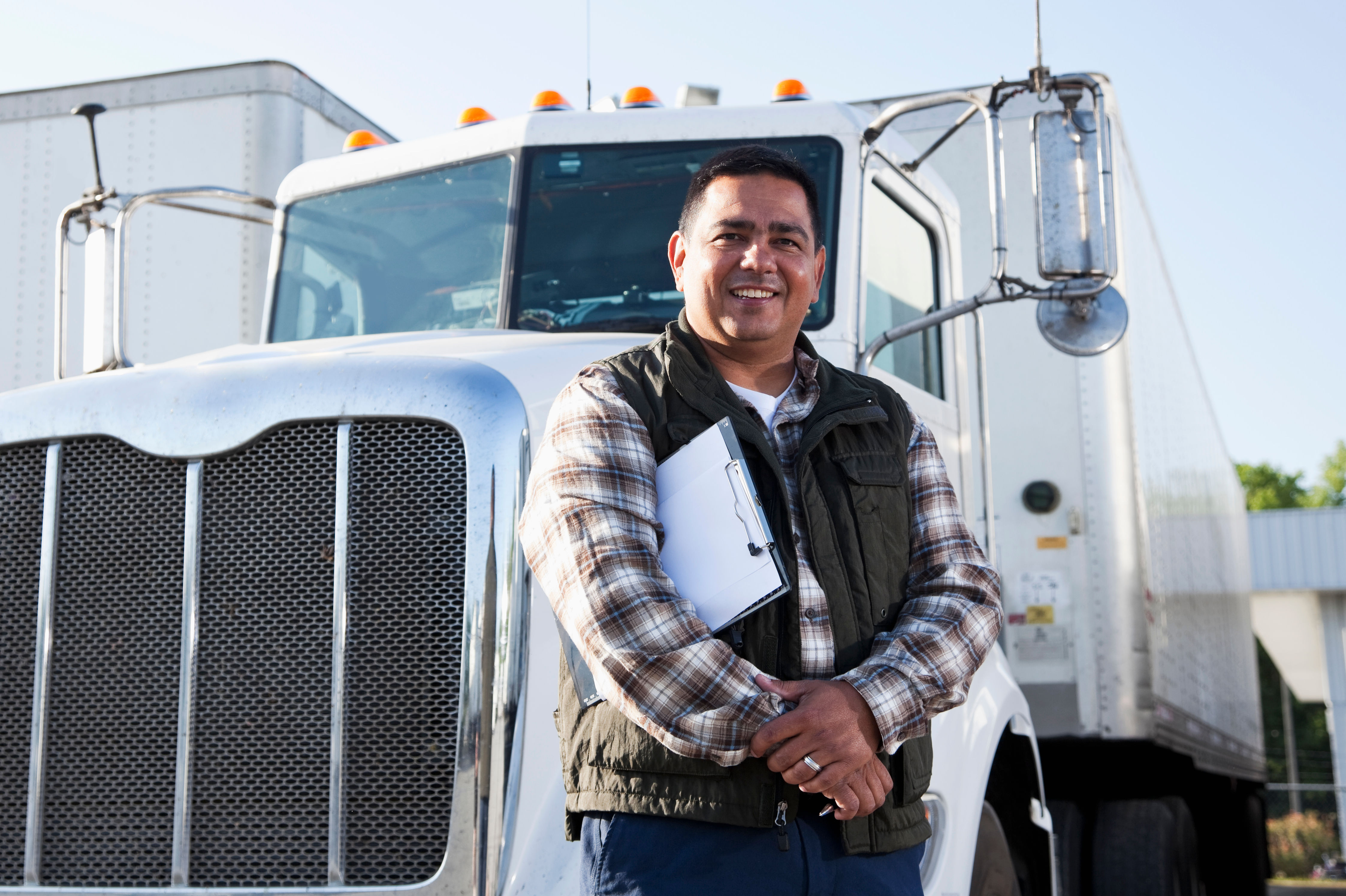 Hispanic truck driver with clipboard