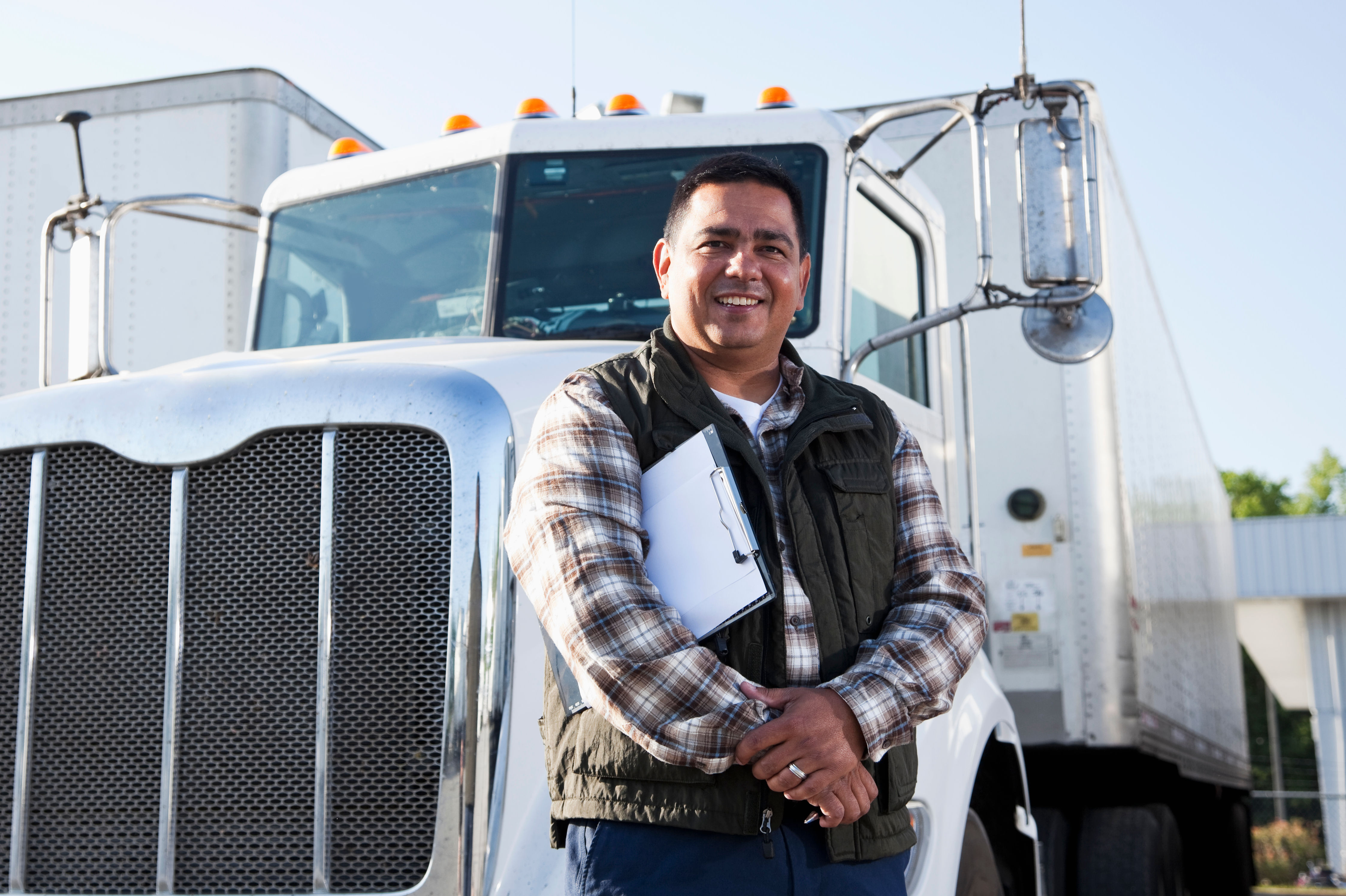 Hispanic truck driver with clipboard
