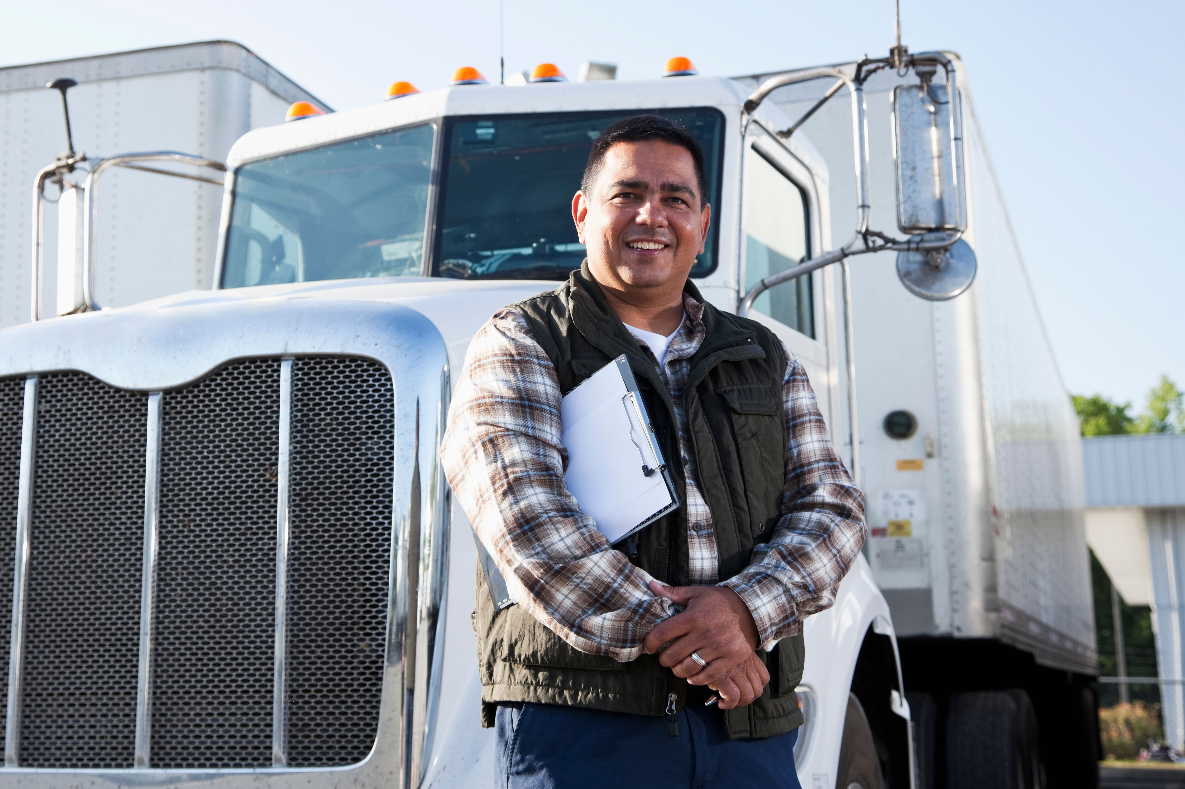 Hispanic truck driver with clipboard
