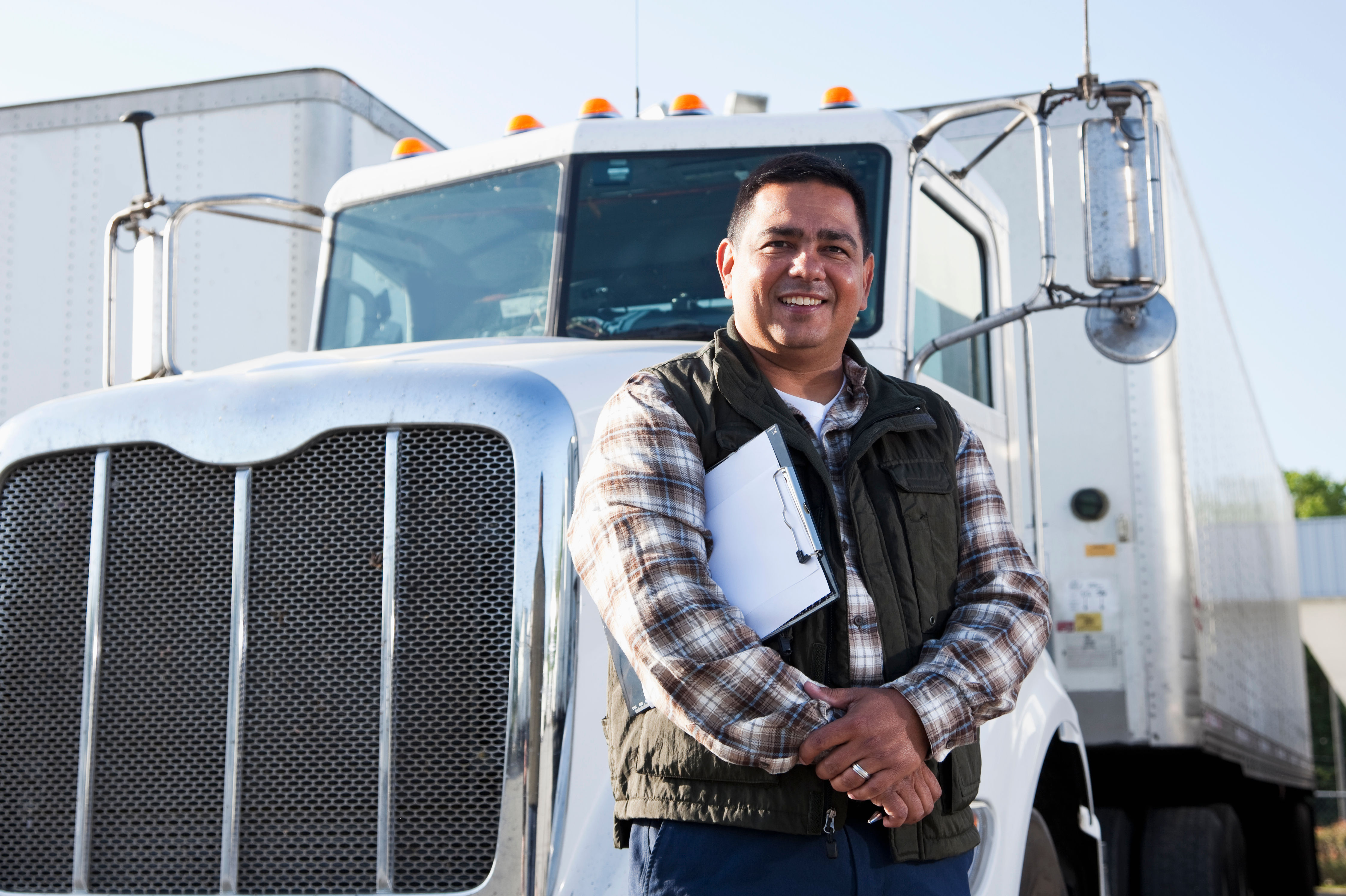 Hispanic truck driver with clipboard