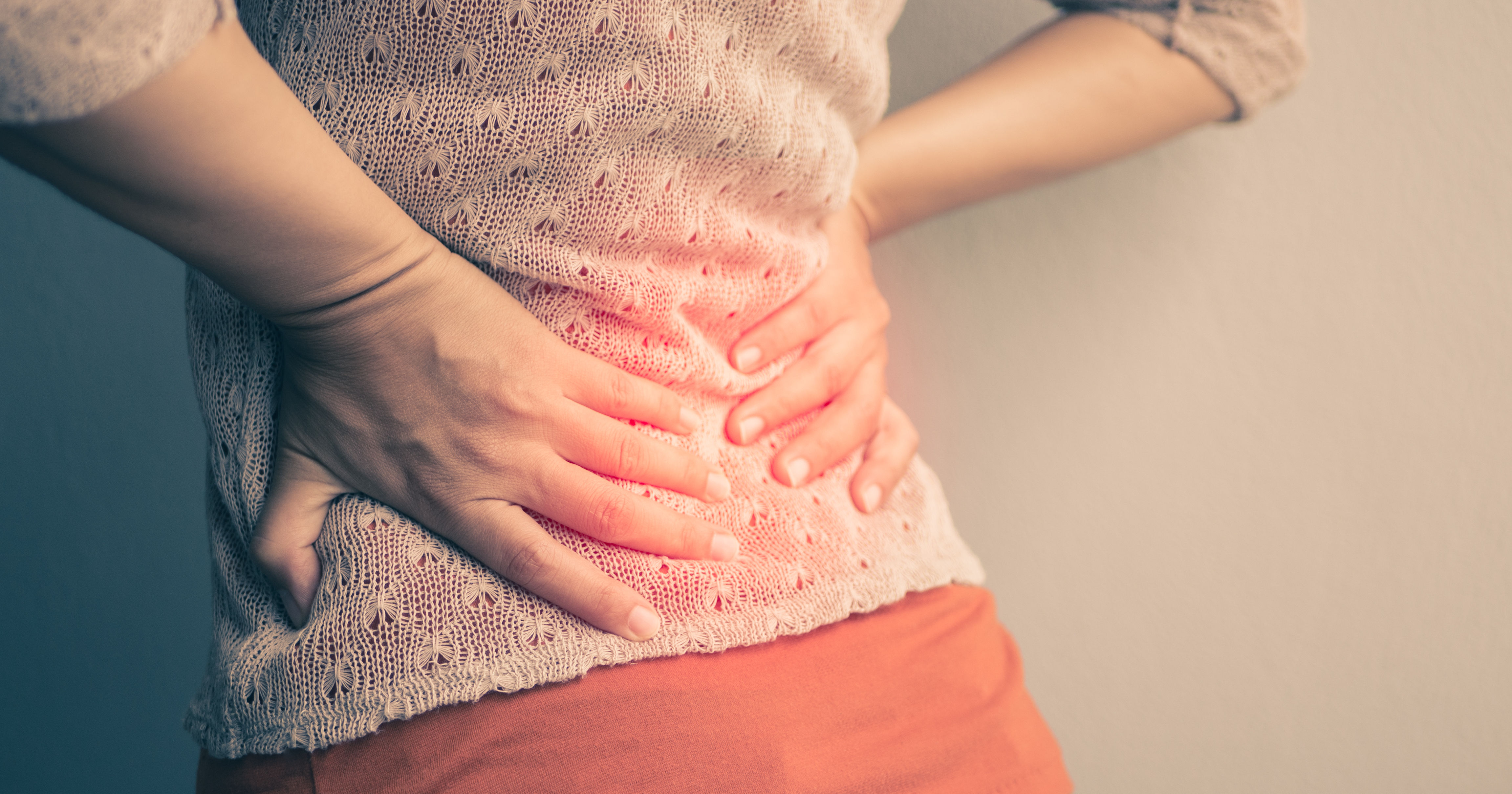 Closeup woman with hands holding her waist back in