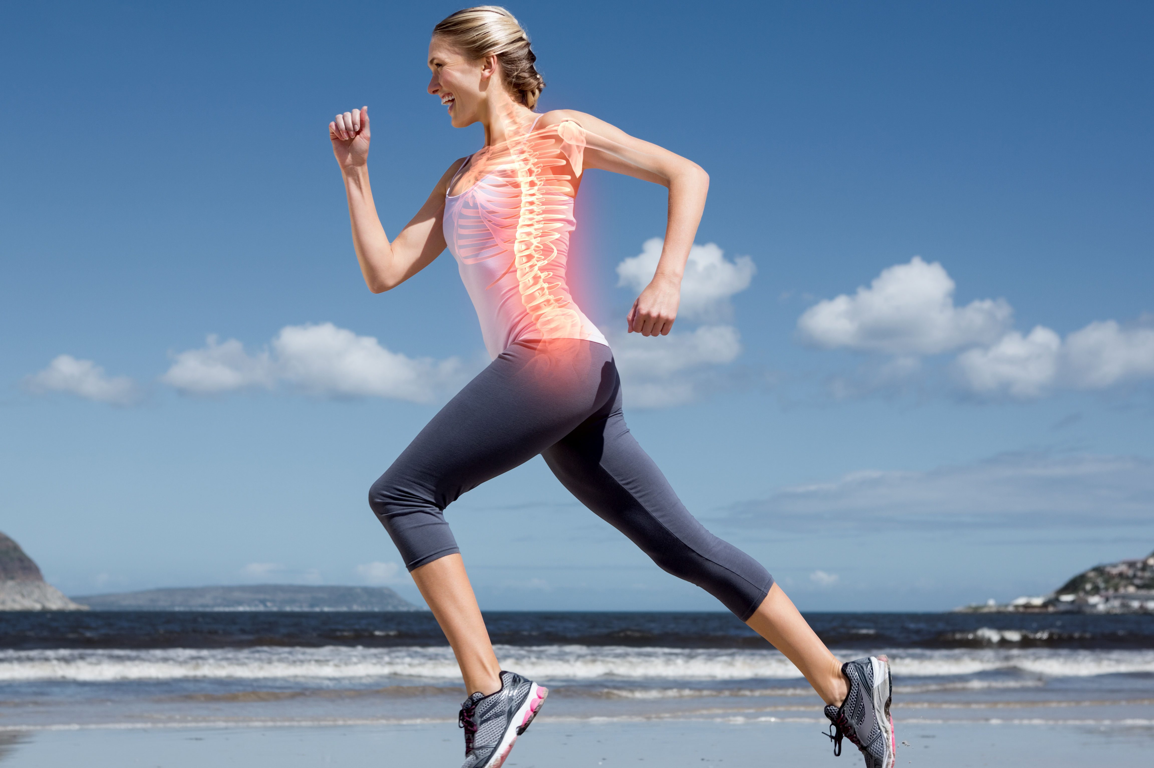 Highlighted back bones of jogging woman on beach