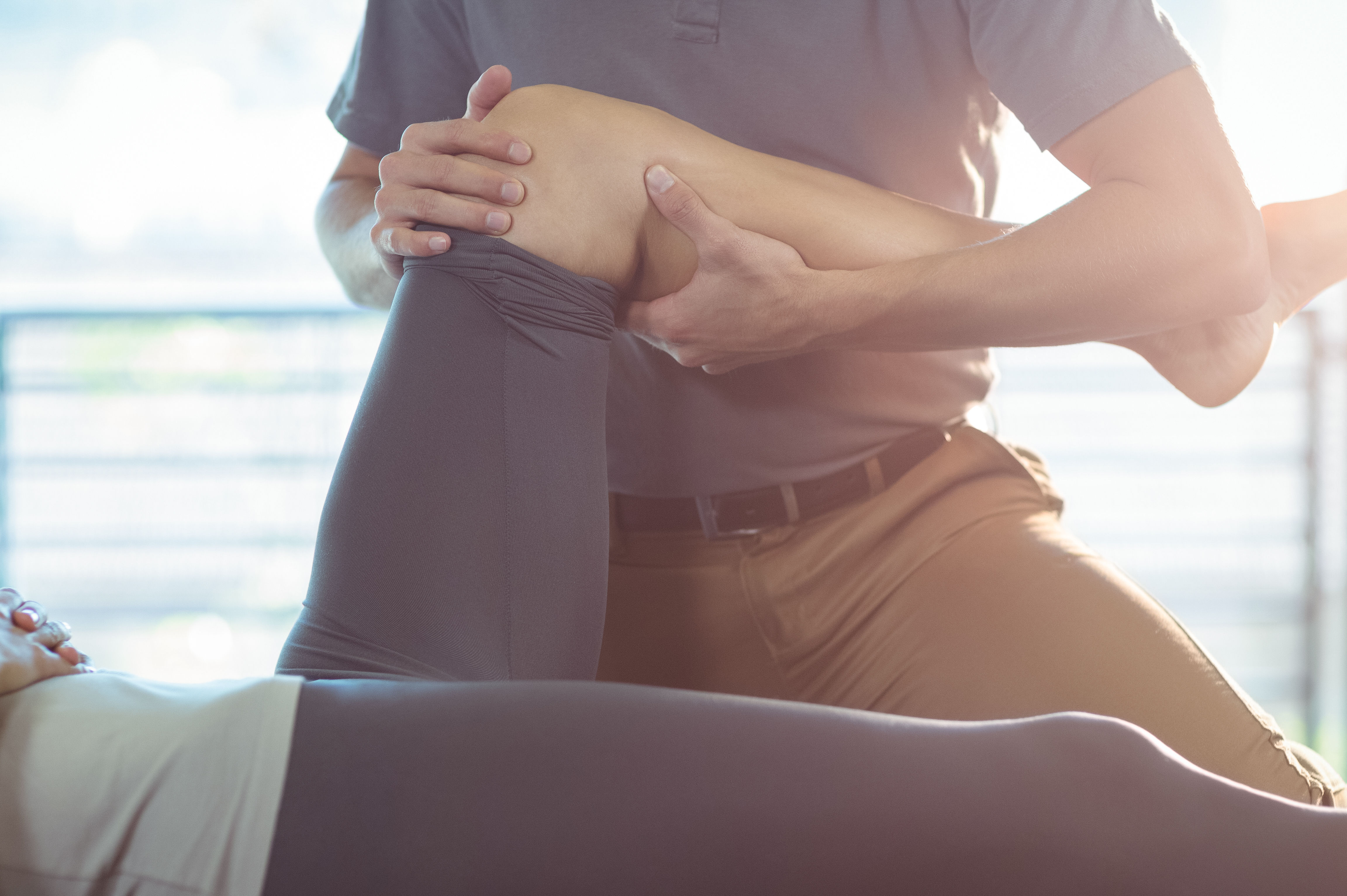 Physiotherapist giving knee therapy to a woman