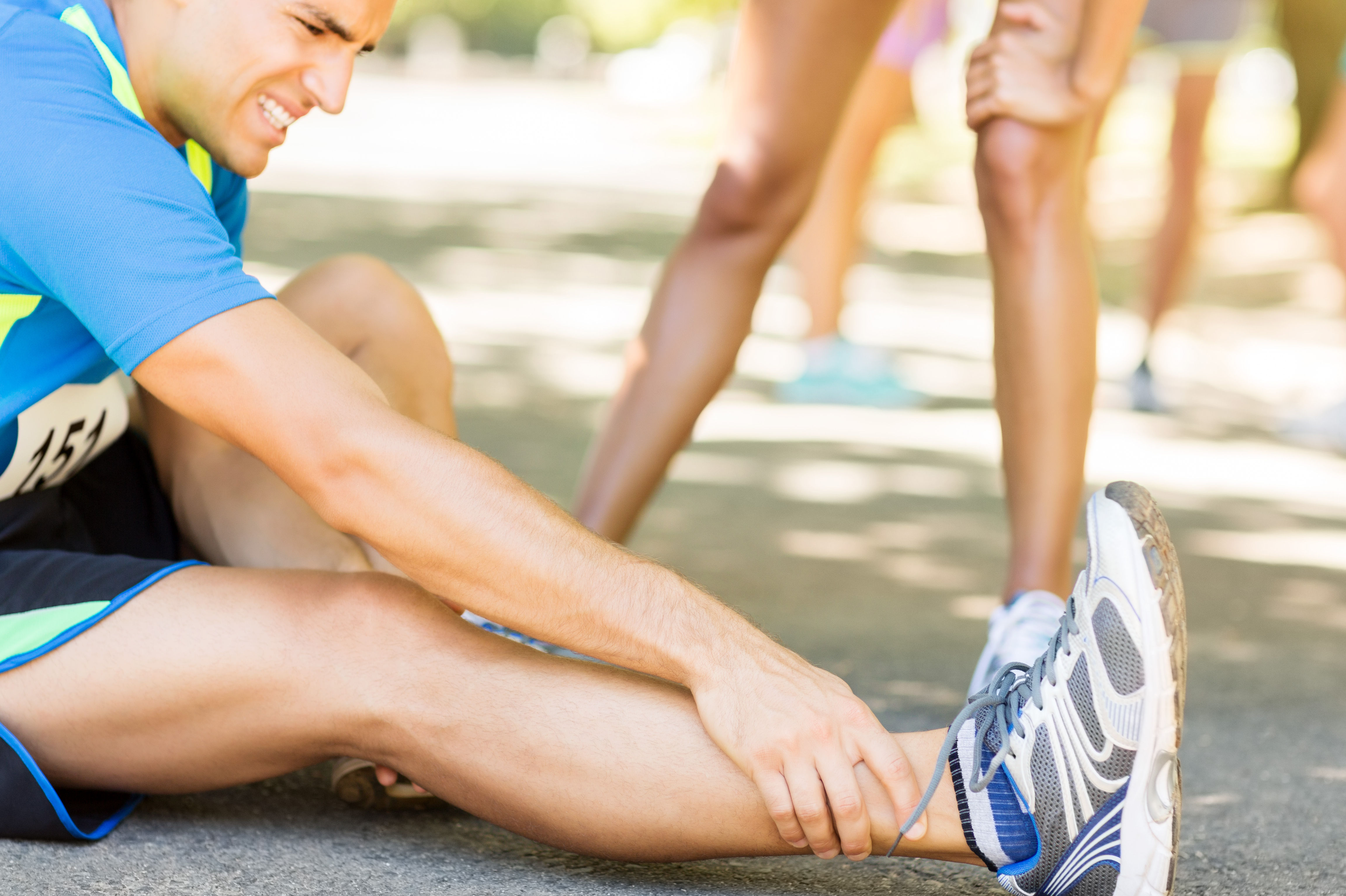 Man Suffering From Ankle Pain On Street During Mar