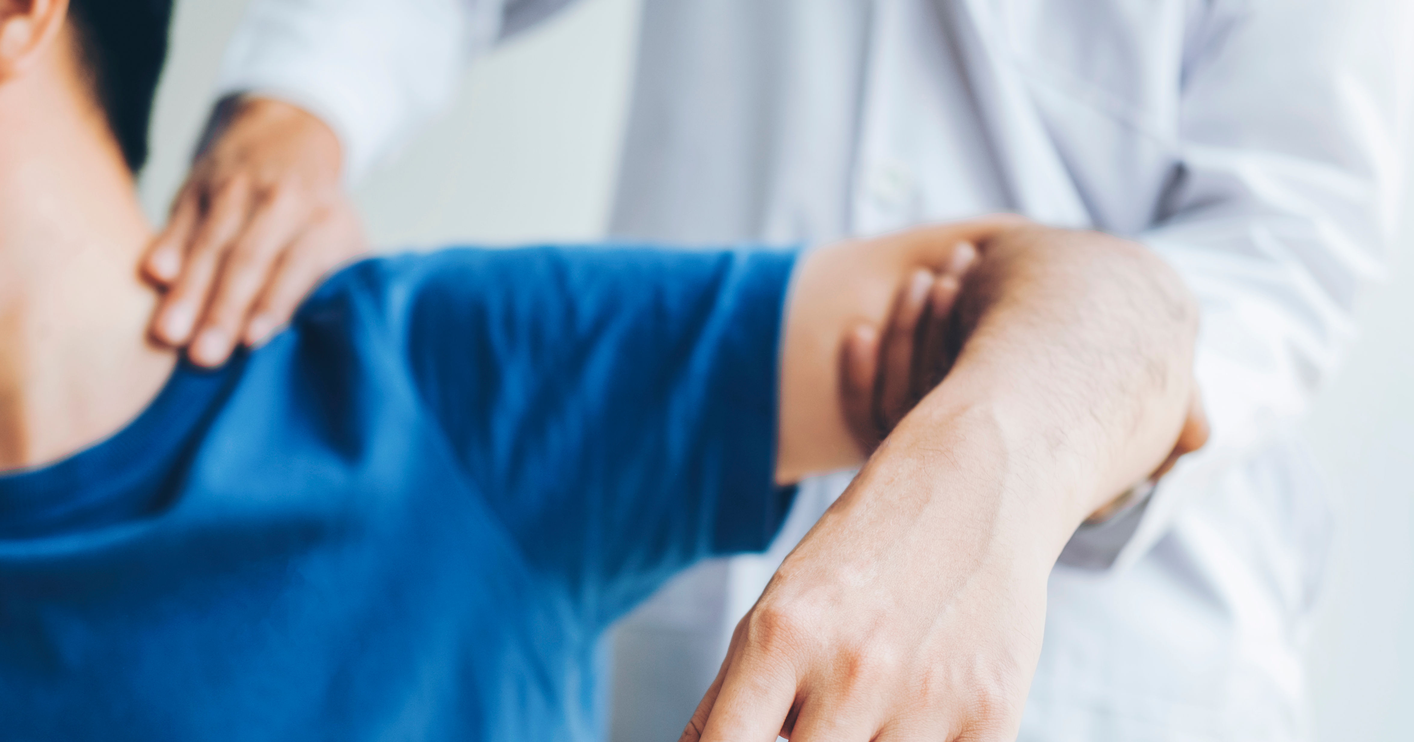 Doctor consulting with patient about shoulder pain