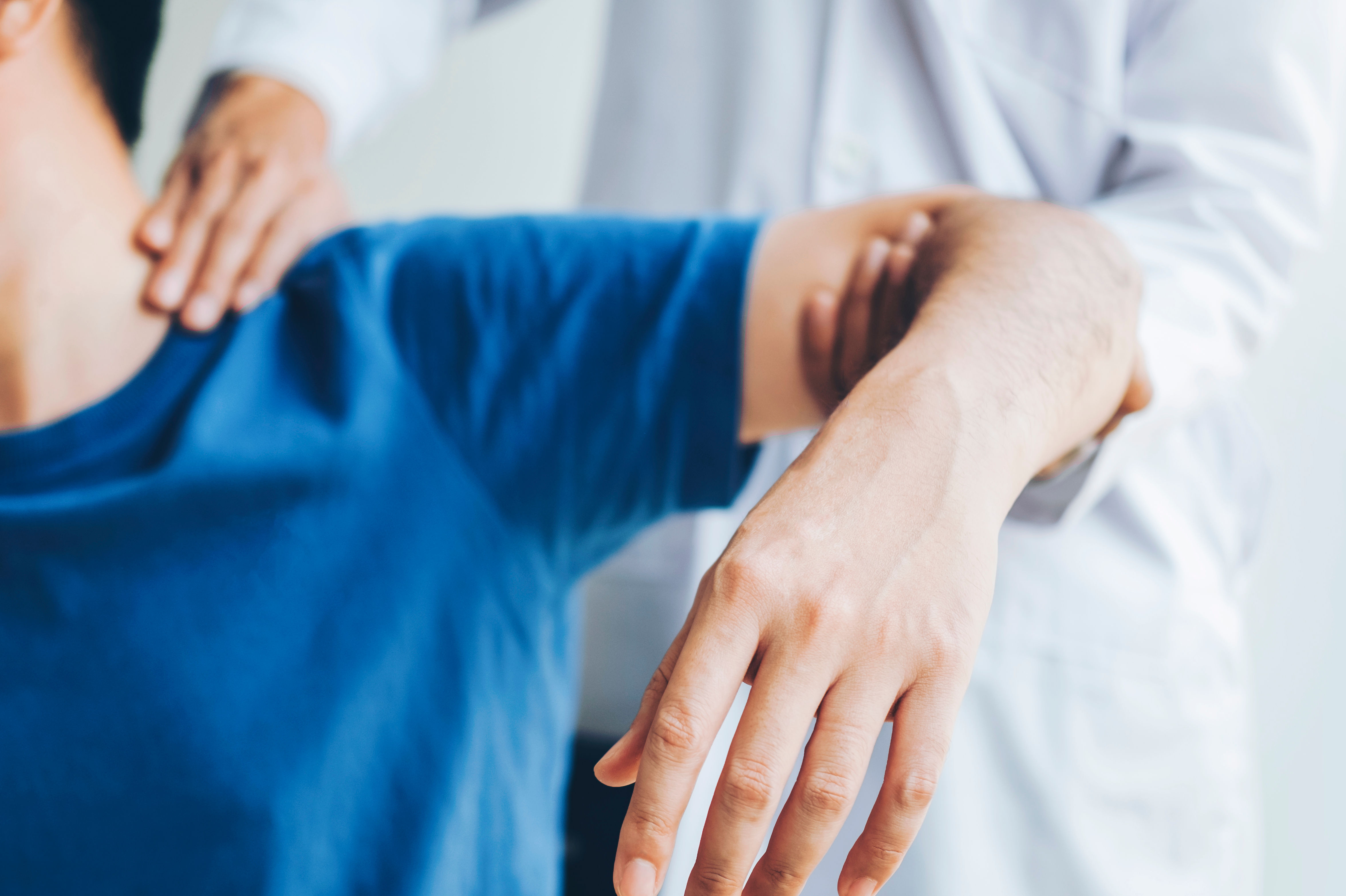 Doctor consulting with patient about shoulder pain