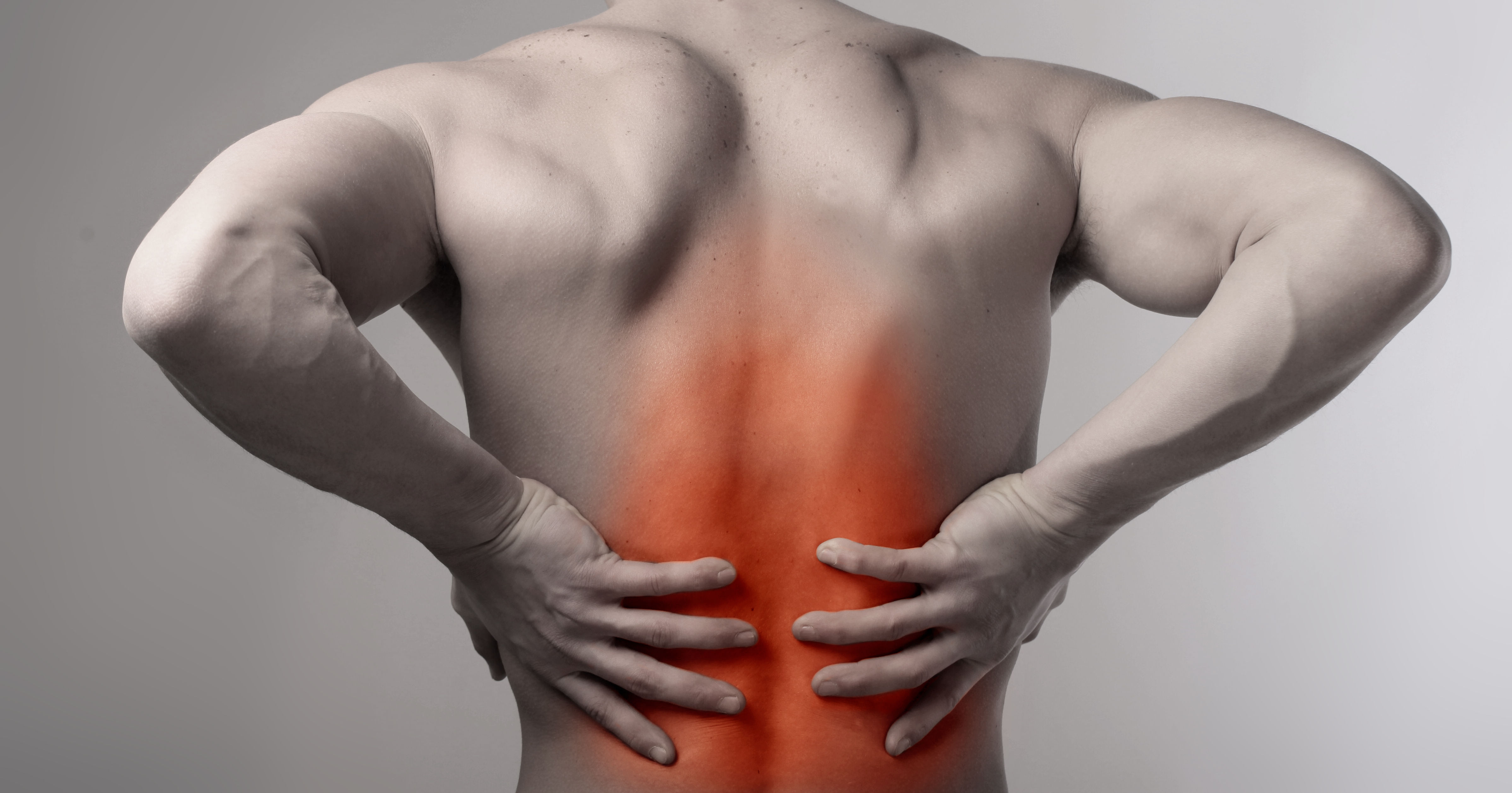 black and white back of upper half of muscular male with low back pain glowing red
