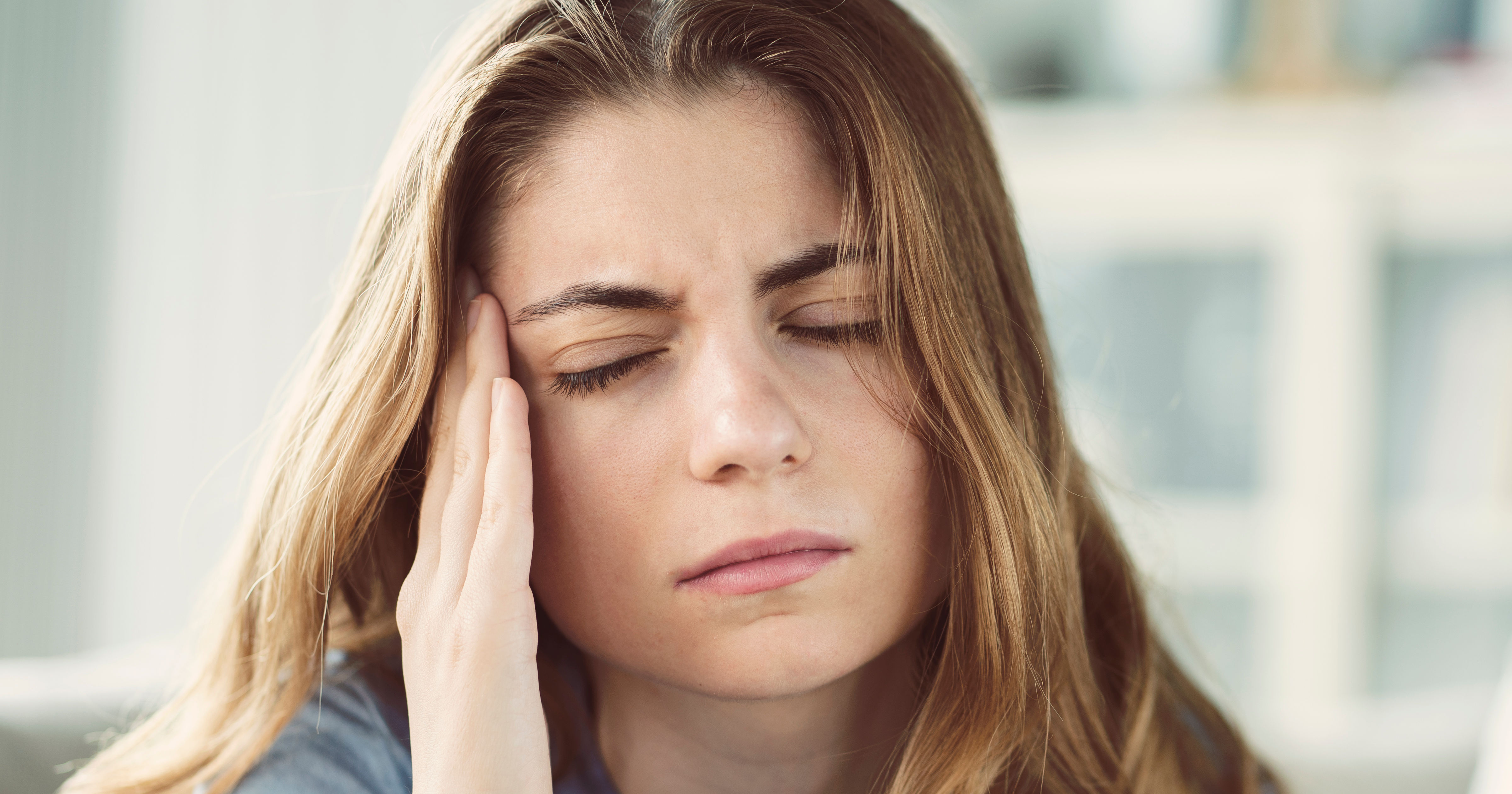 Young woman with headache in home interior