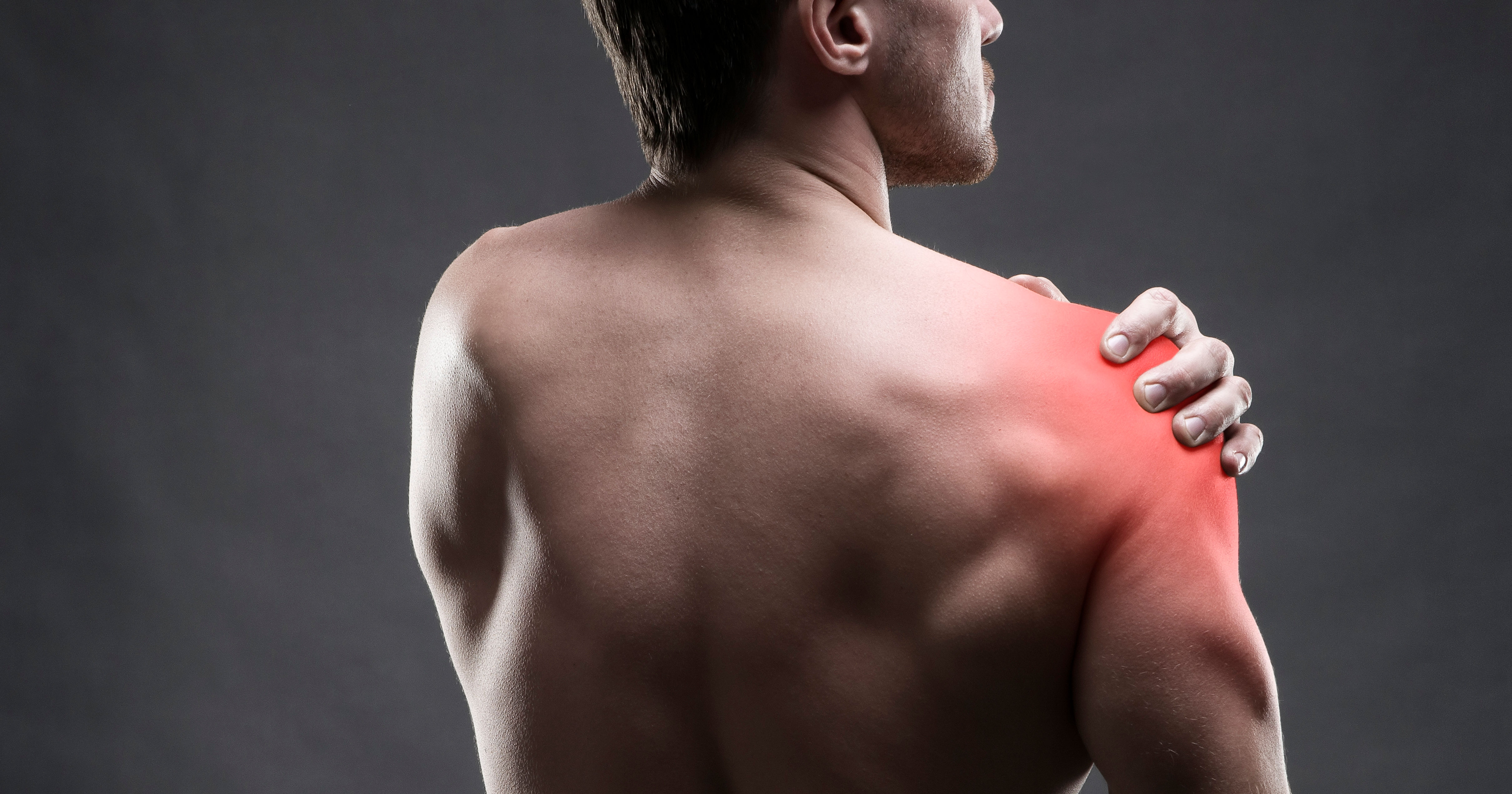 Pain in the shoulder. Muscular male body.