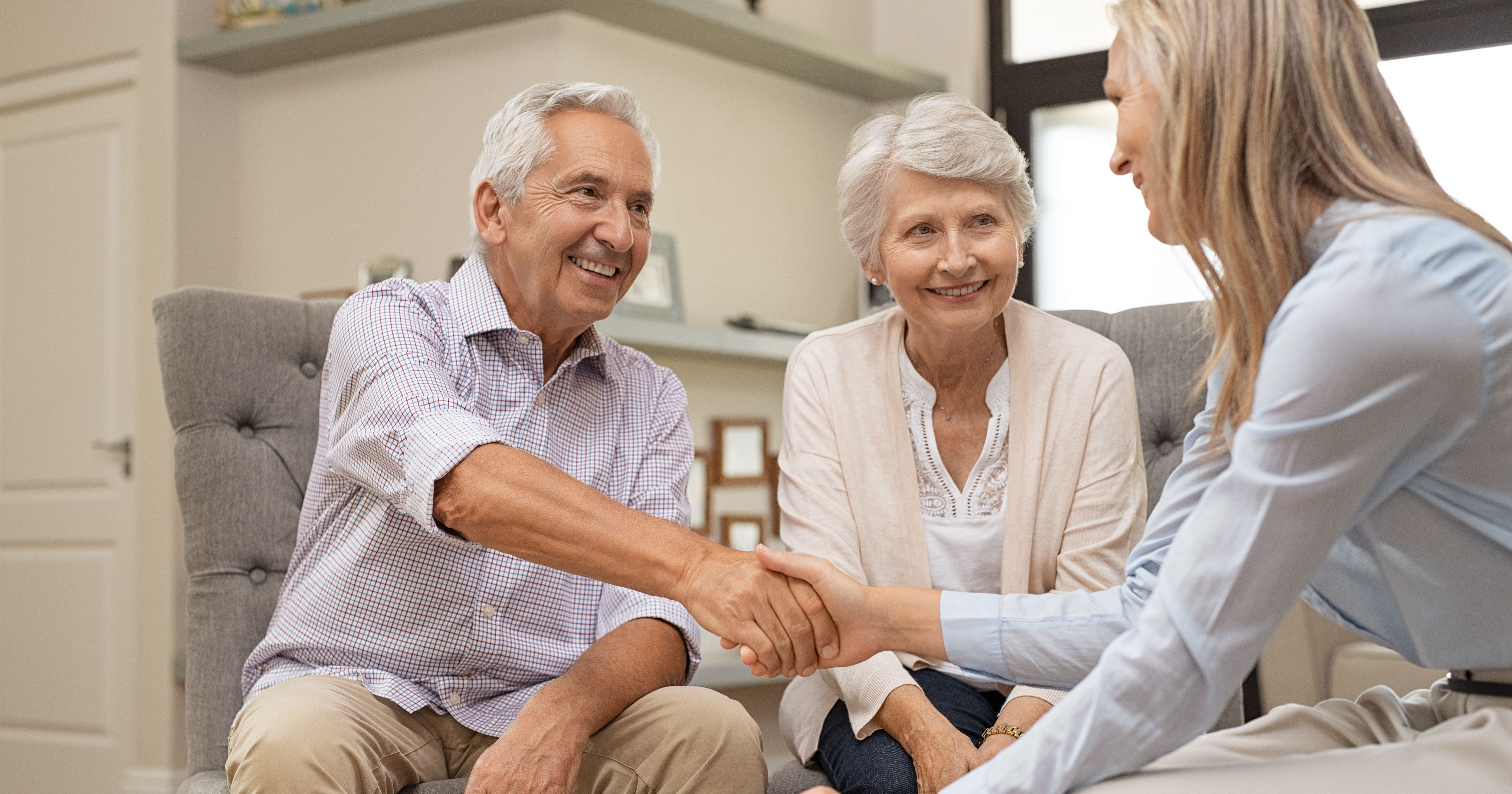 Senior couple shaking hands with financial advisor
