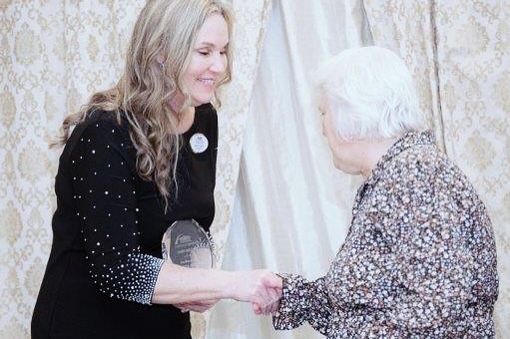 woman who won award shaking hands with the award presenter