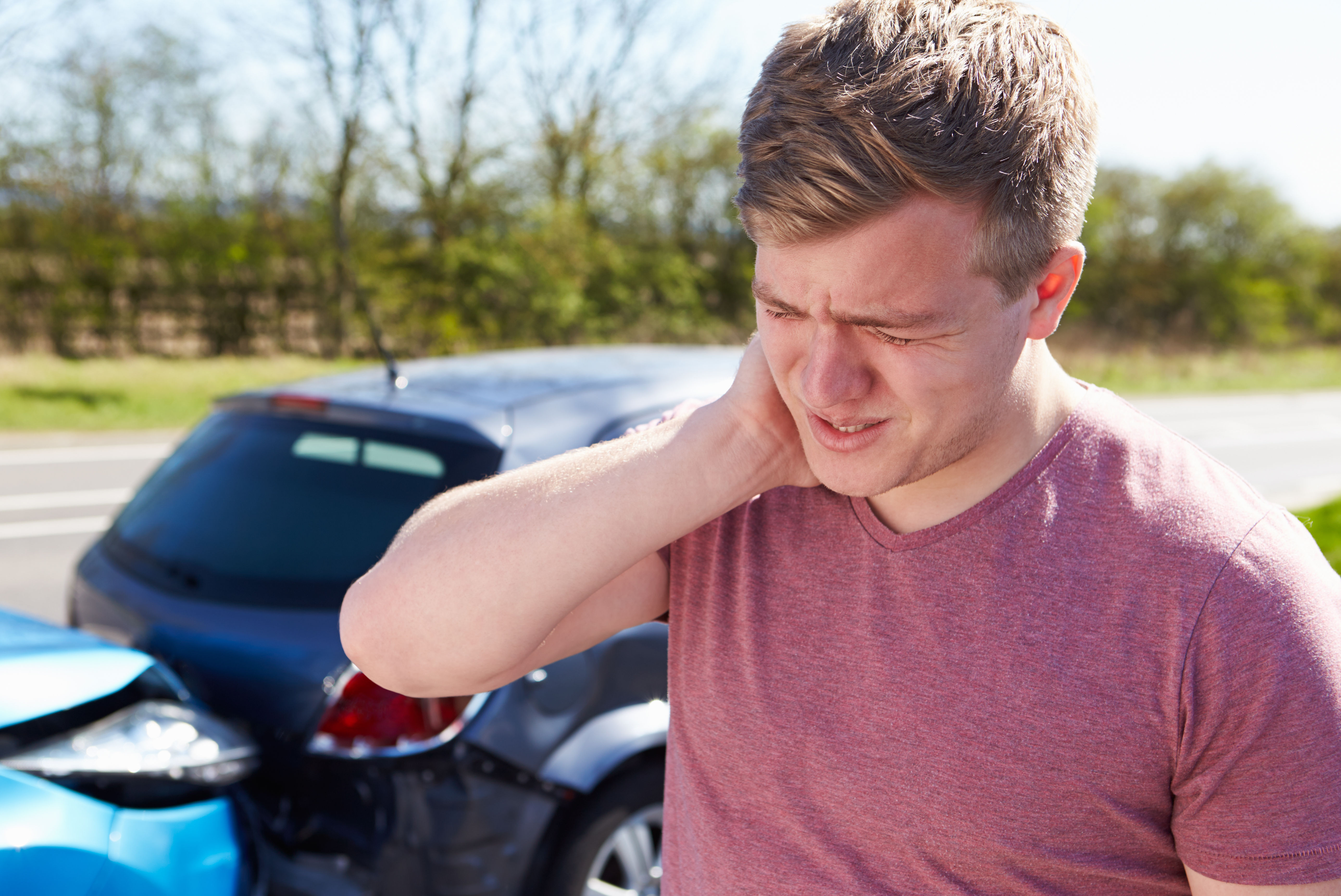person holds neck in pain after auto collision
