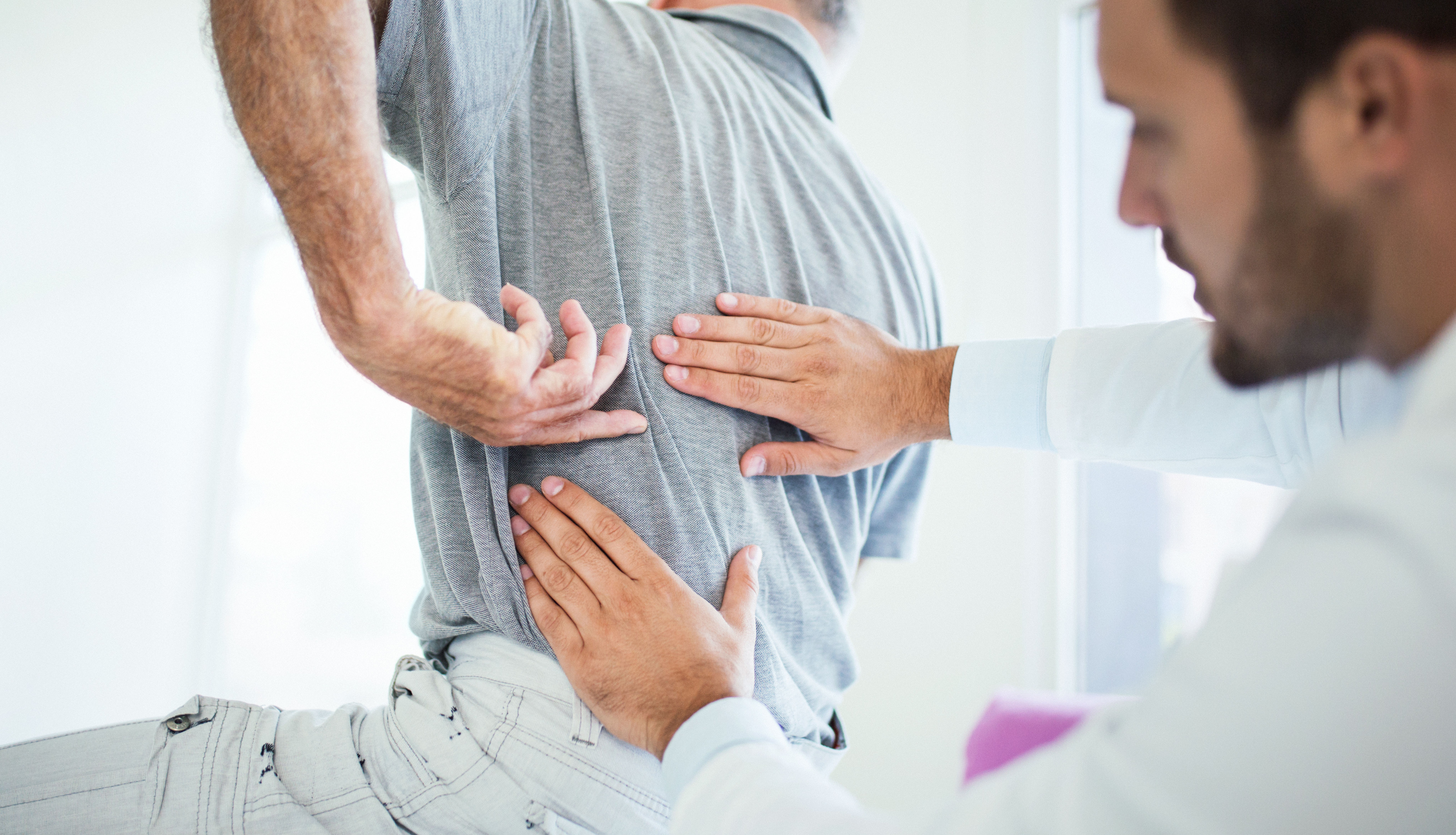 doctor evaluating patient's back pain