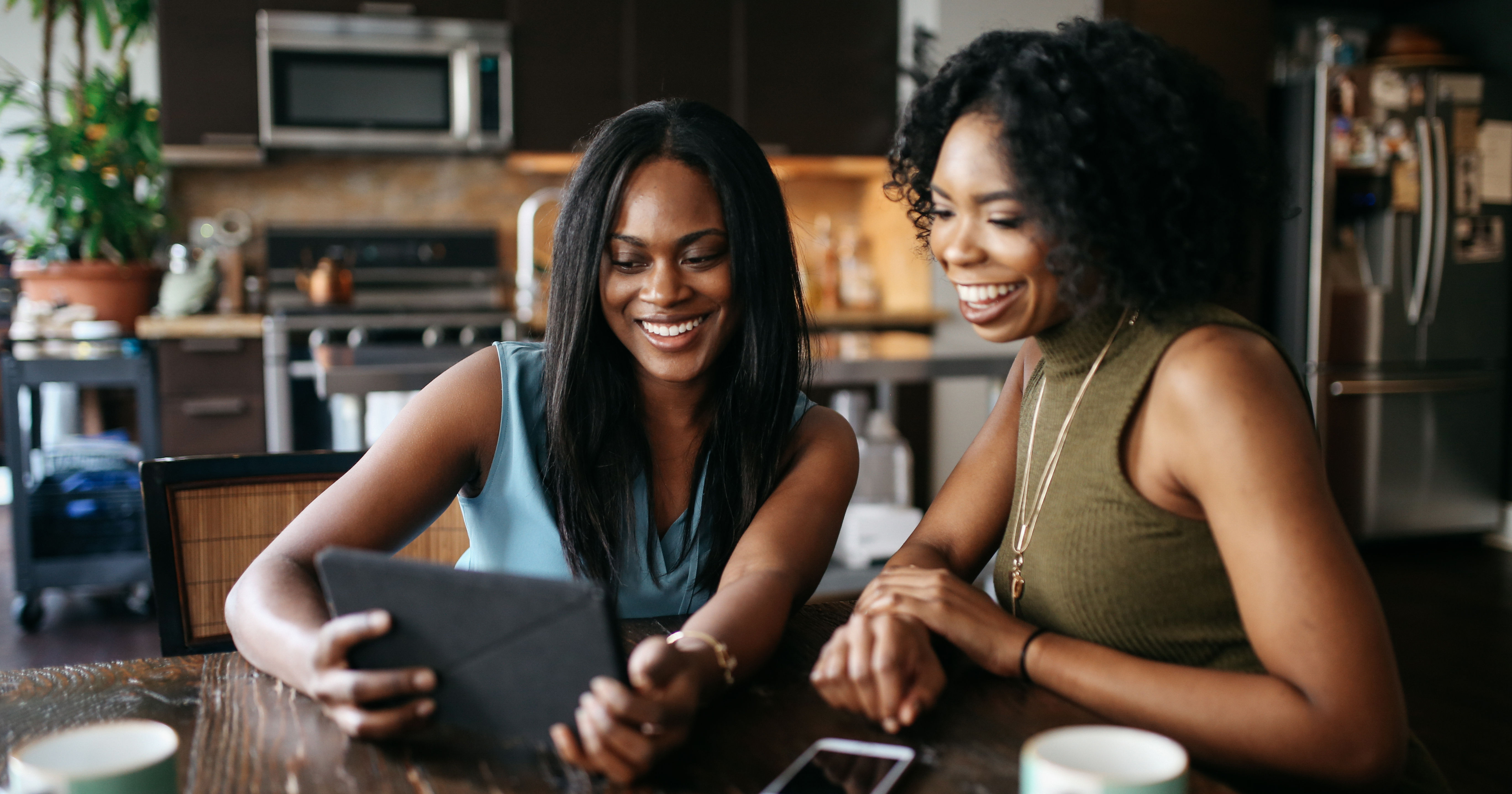 Young women at home, watching stuff on tablet toge