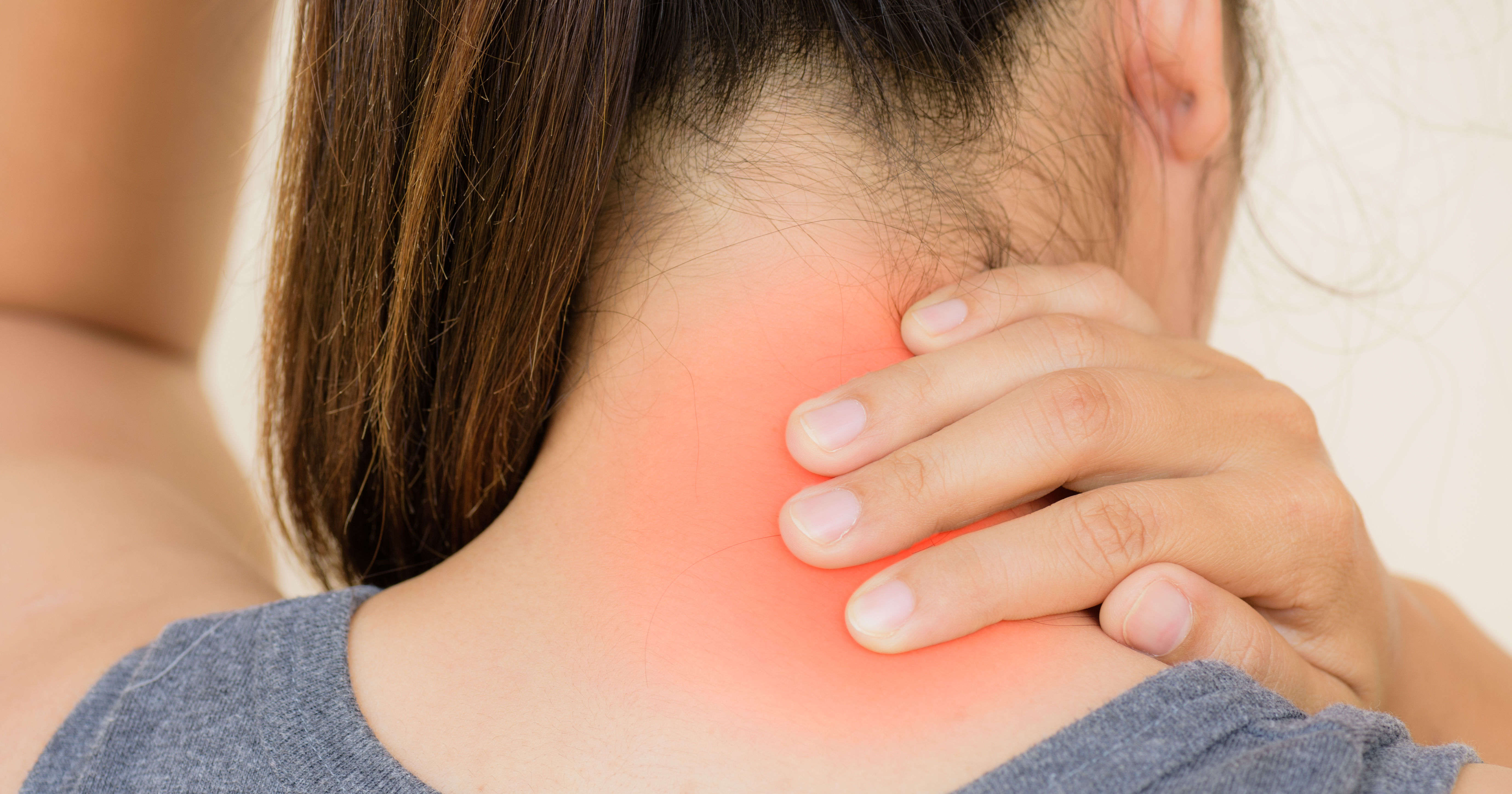 close up female right hand back of neck red glowing 