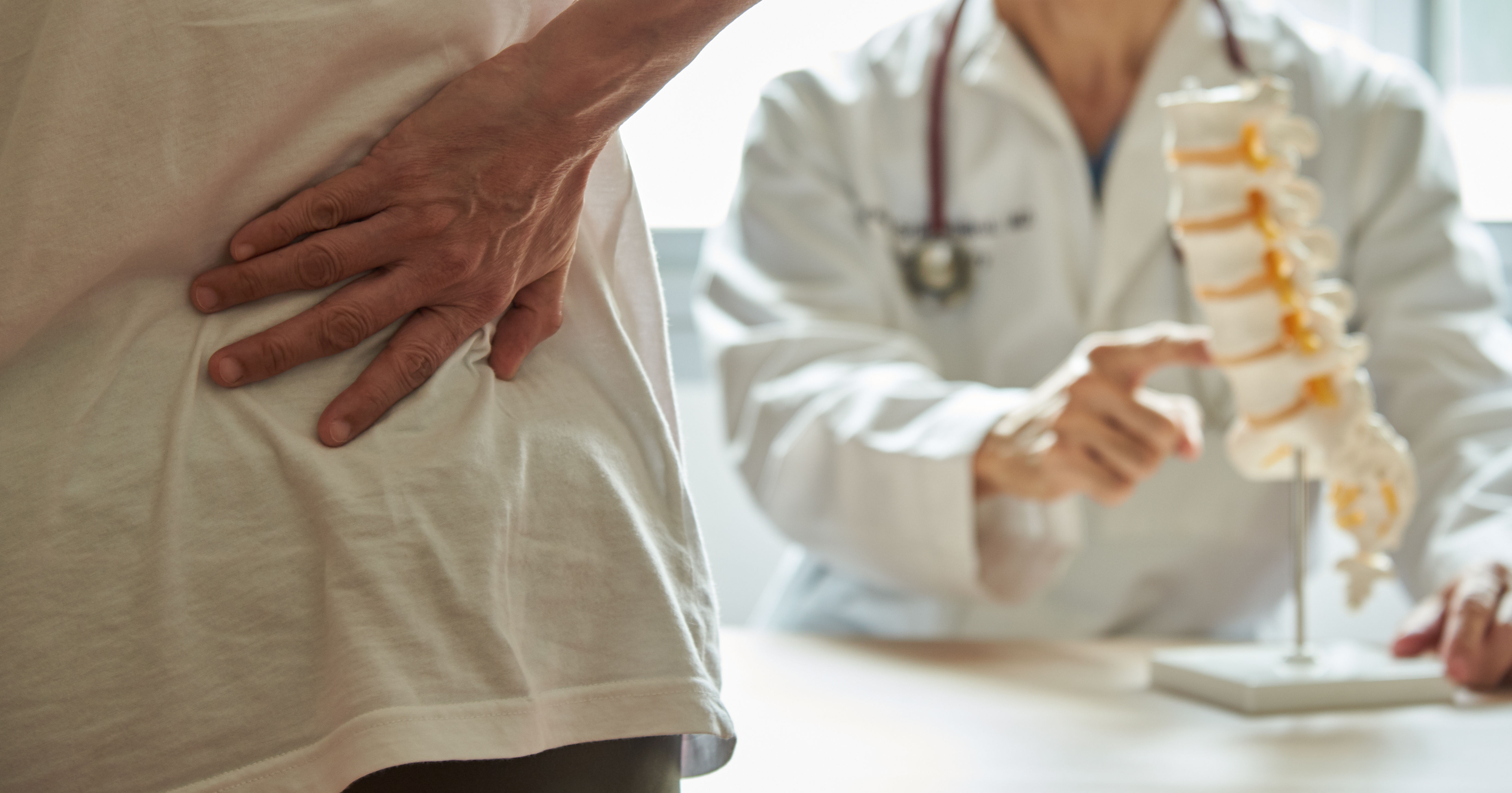 A doctor explaining lumbar anatomy to back pain pa