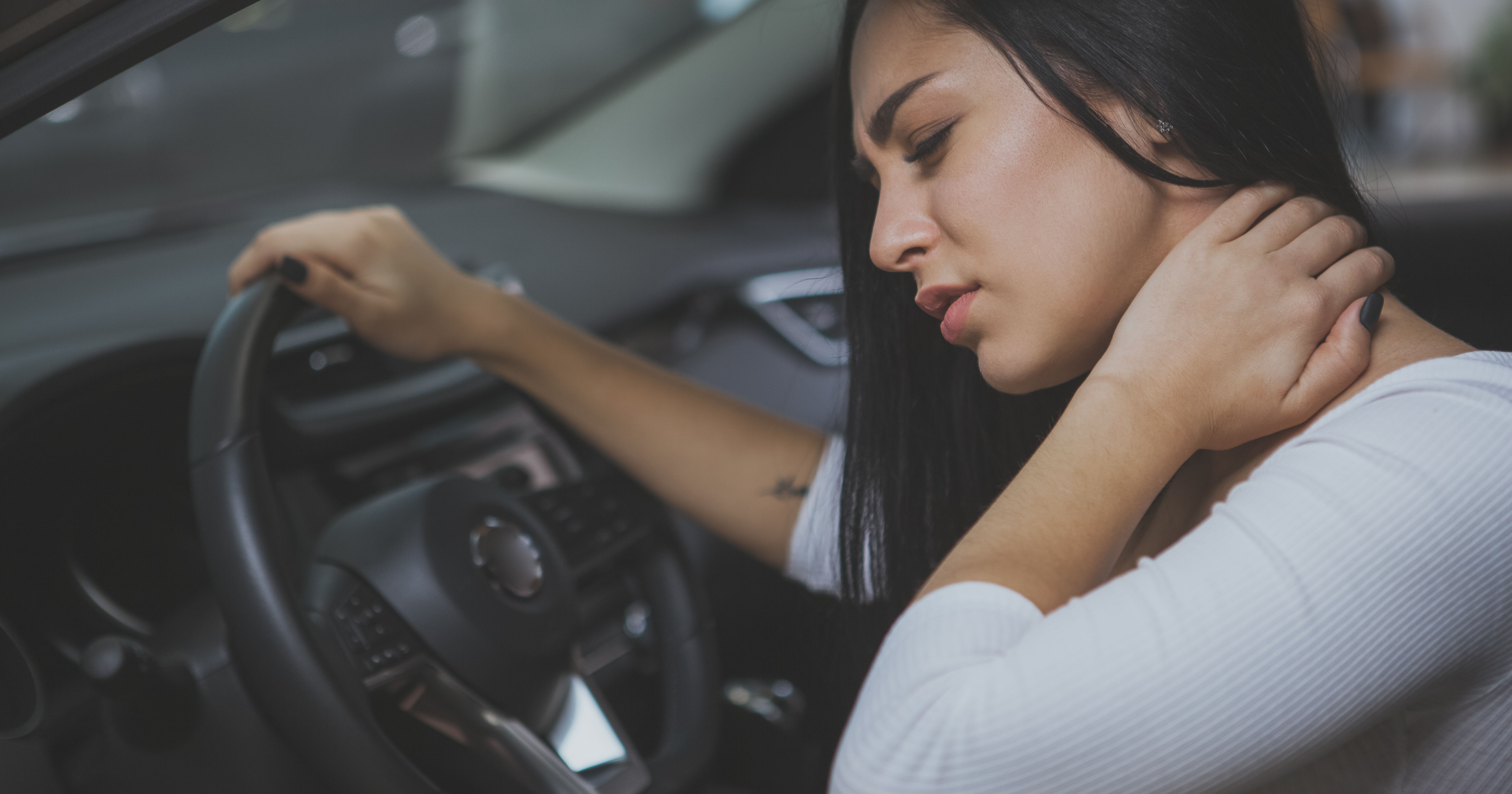 Female driver rubbing her aching neck after long d